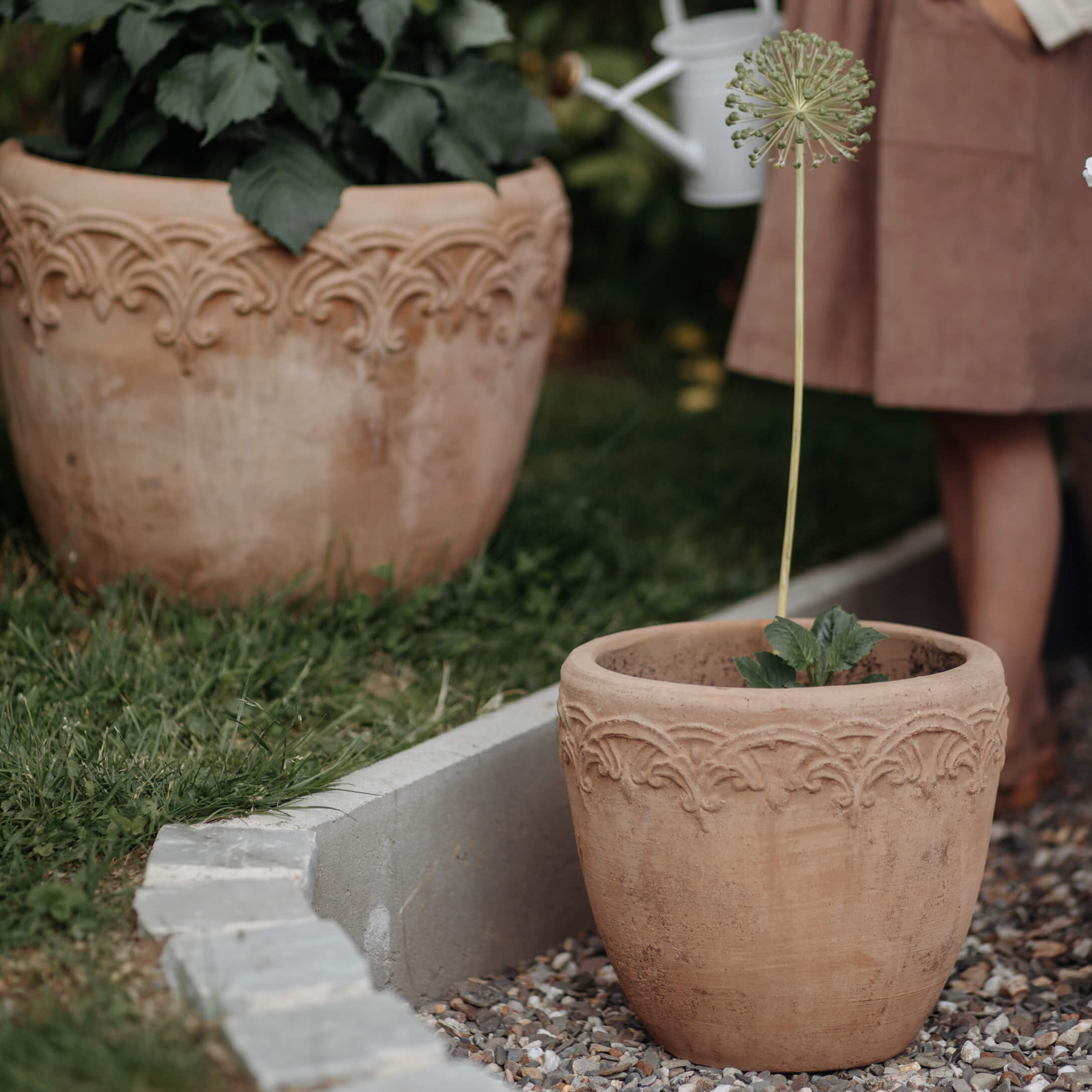 Pot en terre cuite avec motif décoratif beige naturel dans un jardin extérieur