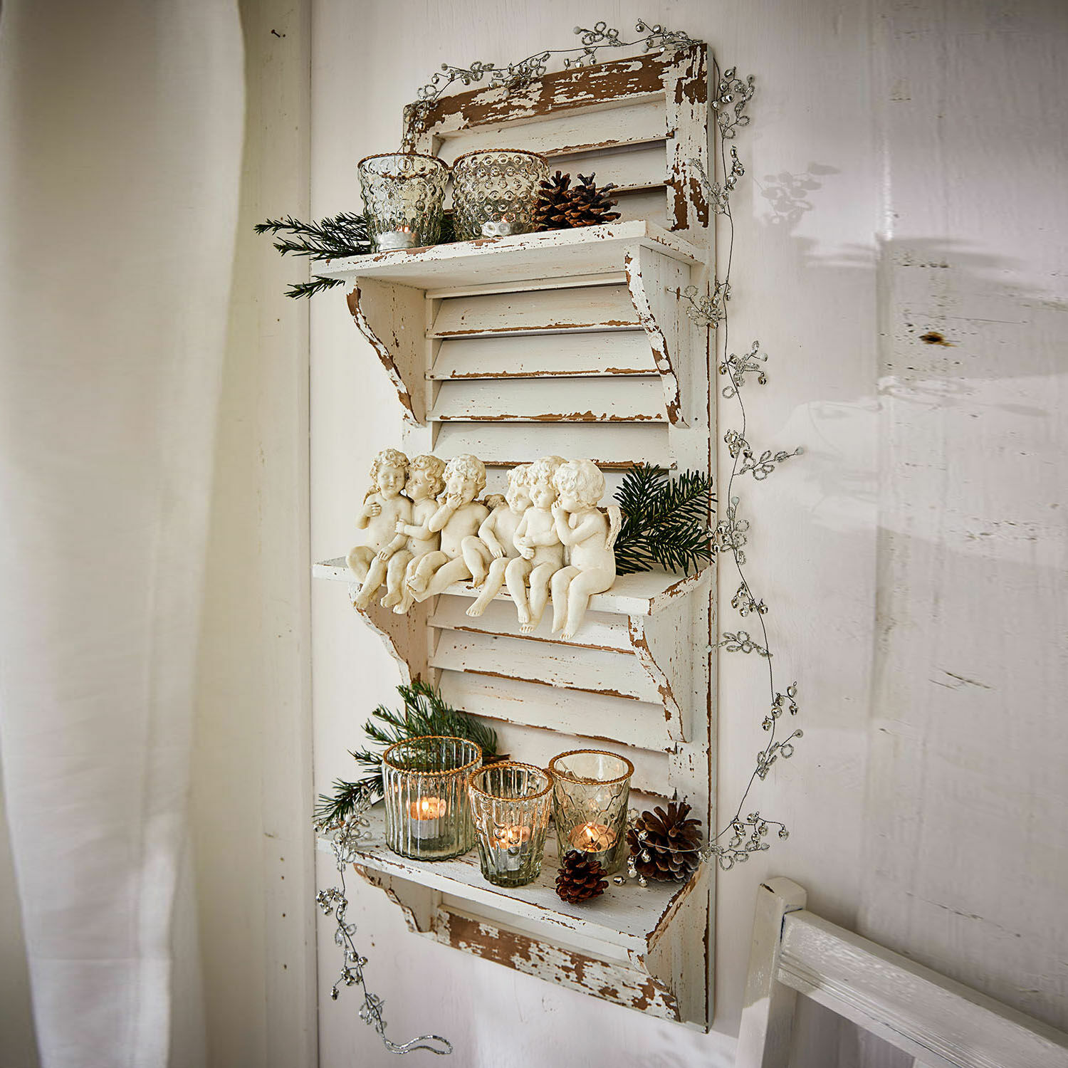 Étagère murale en bois blanc vieilli avec figurines d'anges et photophores pour décoration festive