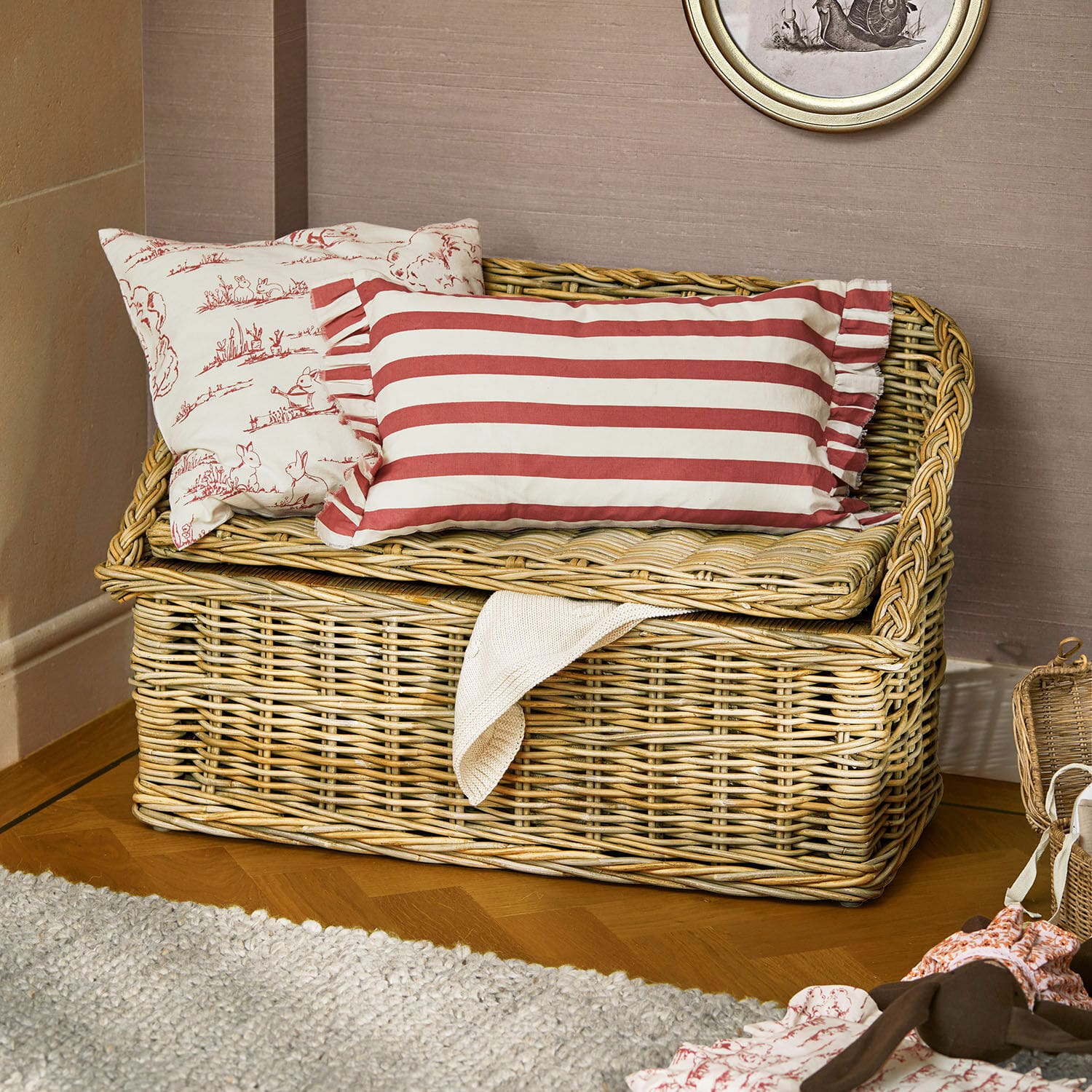 Banc coffre Fableton Coffre en rotin naturel avec coussins rayés rouges et motifs lapins, rangement décoratif pour intérieur