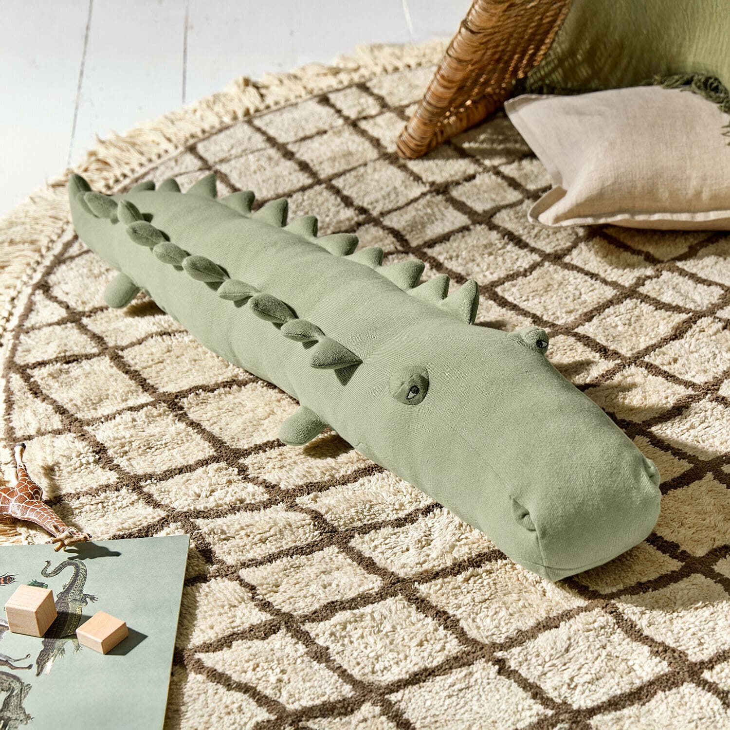 Knuffeltje Zimpy Zachte groene krokodillenknuffel op een beige tapijt met geometrisch patroon