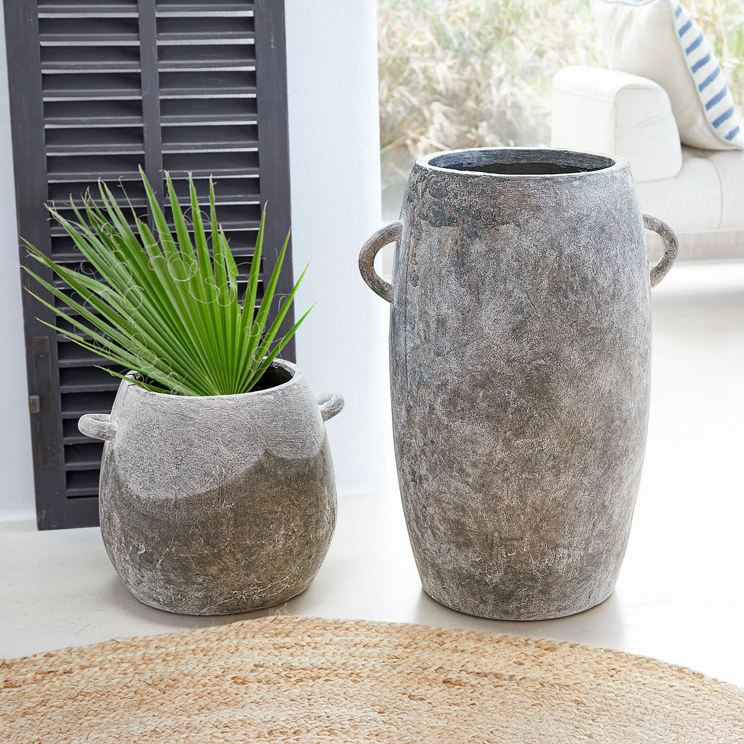 Sierpot set van 2 Cœuron Twee grijze betonnen potten in verschillende maten met handvatten, één met groen blad, interieurdecoratie
