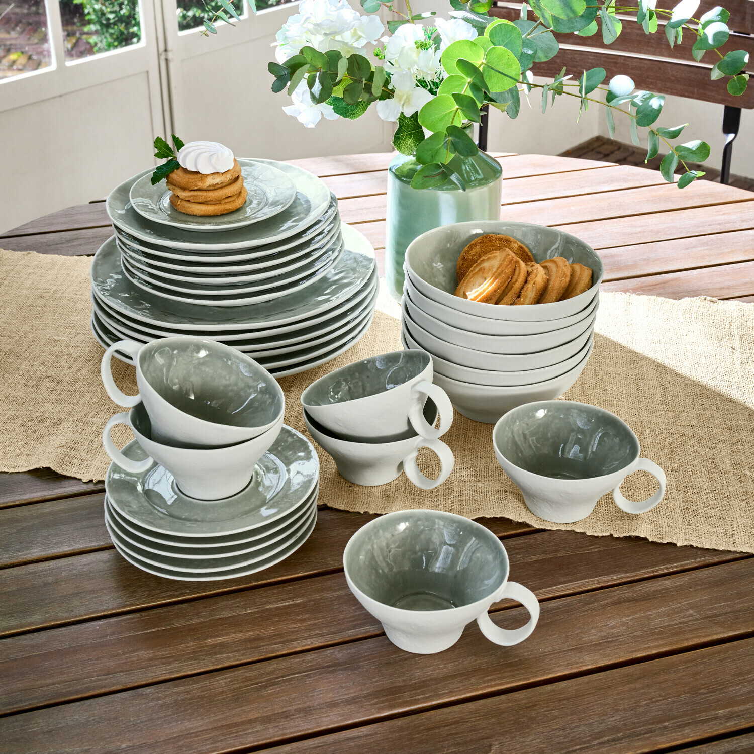 Servies set van 30 Braganza Grijs-witte keramische servies set op houten tafel met koekjes en bloemstuk