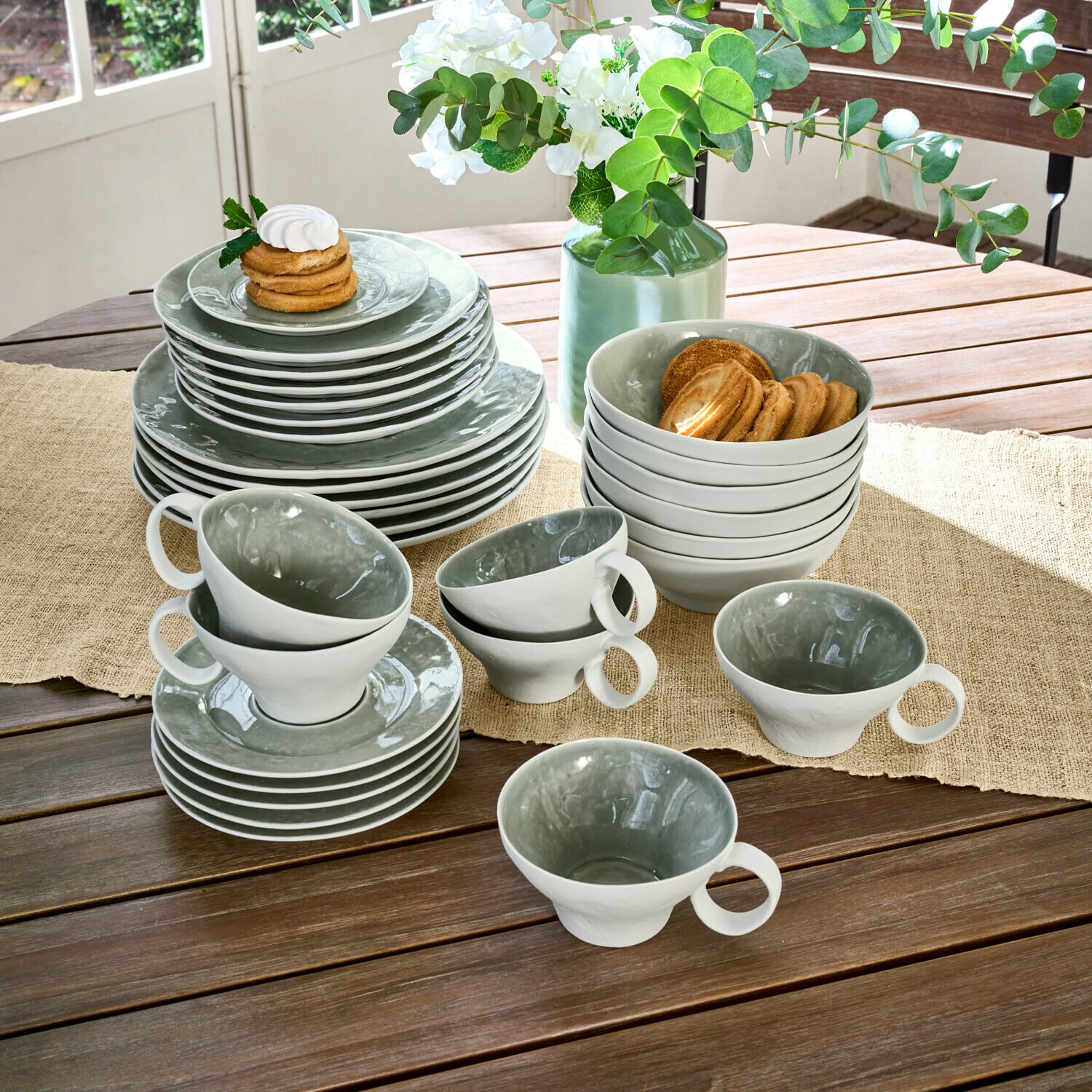 Servies set van 30 Braganza Grijs-witte keramische servies set op houten tafel met koekjes en bloemstuk