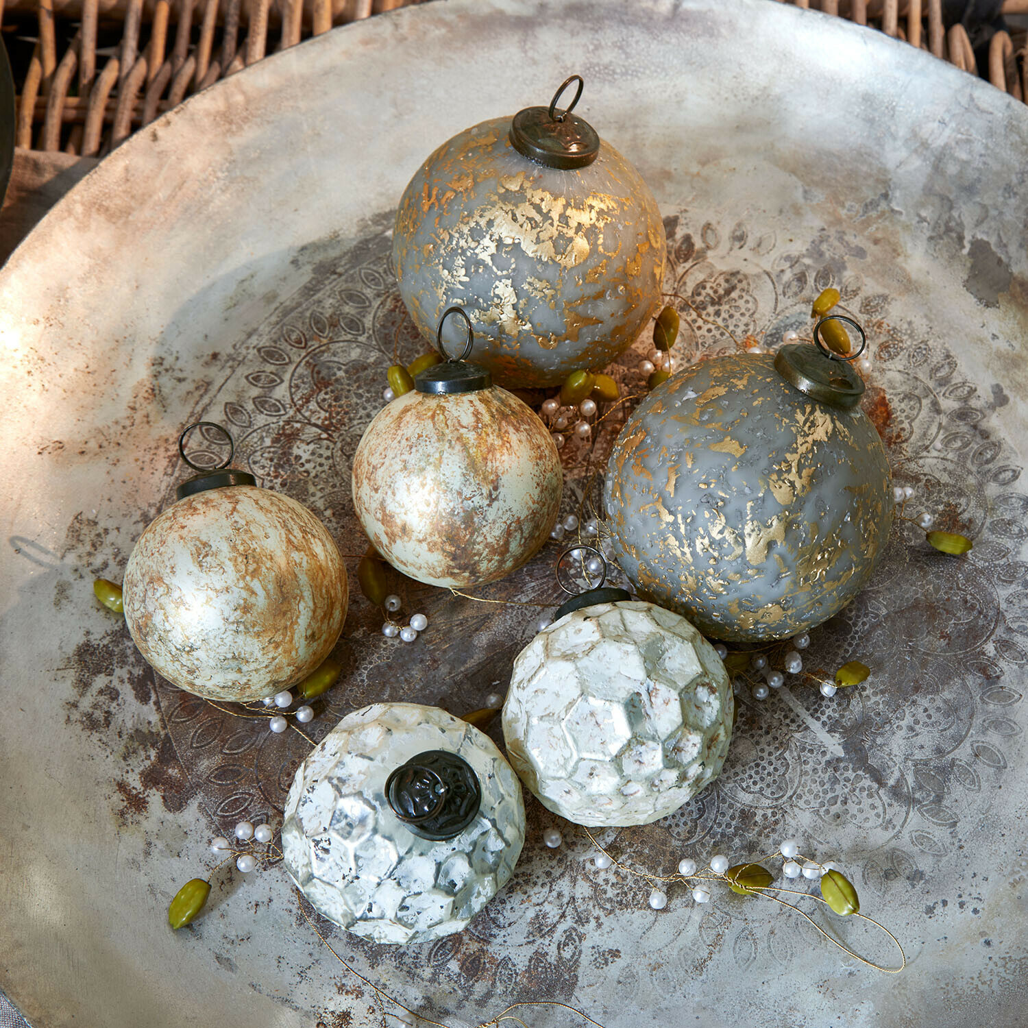 Set de 6 boules de Noël Bellezia Ensemble de six boules de Noël décoratives gris et blanc avec finition métallique posées sur un plateau décoratif