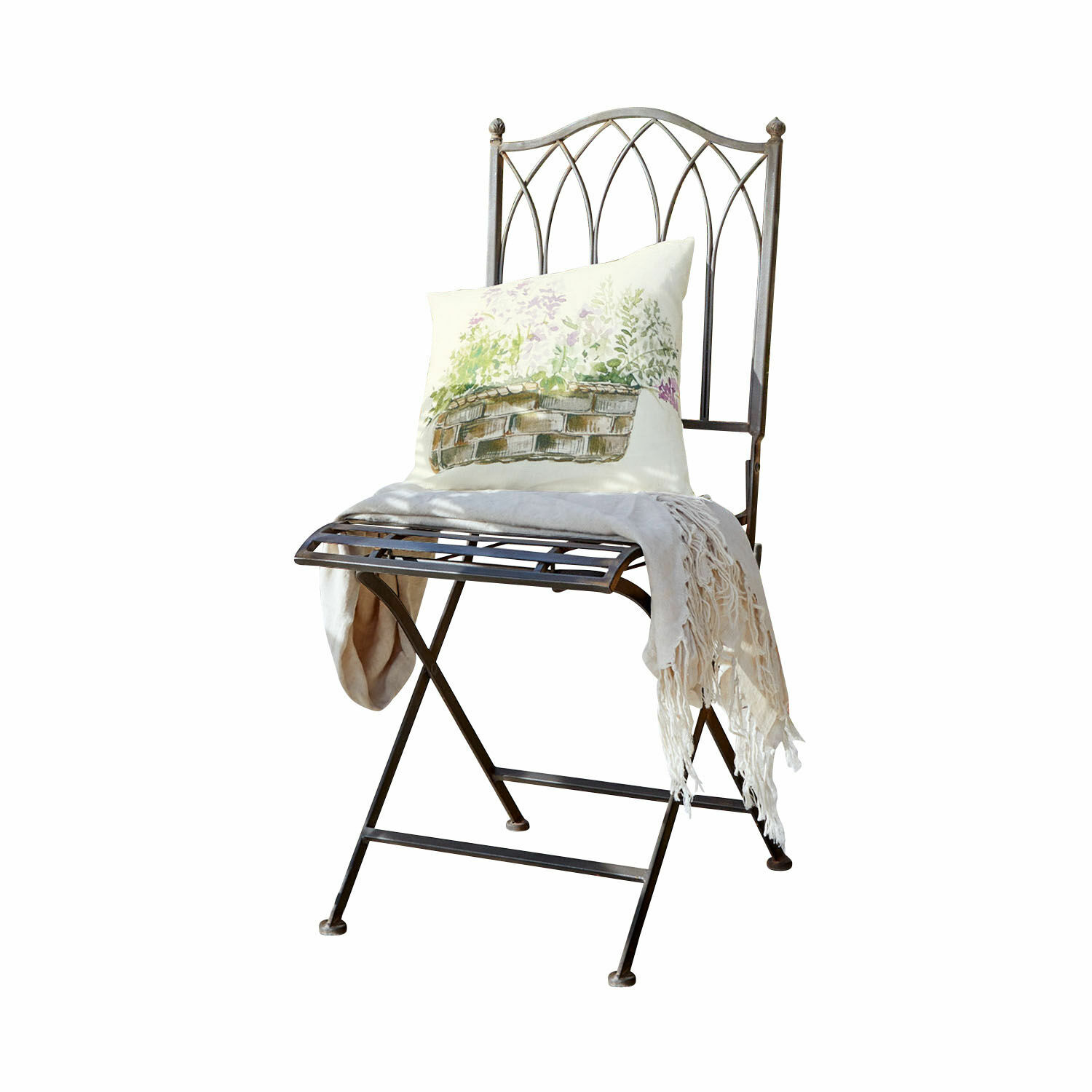 Chaise Brignoles Chaise en métal avec dossier décoratif, coussin clair imprimé et plaid crème à franges posé dessus