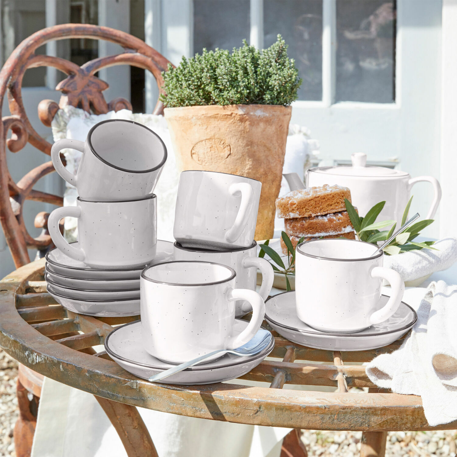 Lot de 6 tasses et soucoupes Biarré Ensemble de tasses en céramique blanche avec soucoupes sur une table rustique en extérieur avec gâteau et pot de fleurs