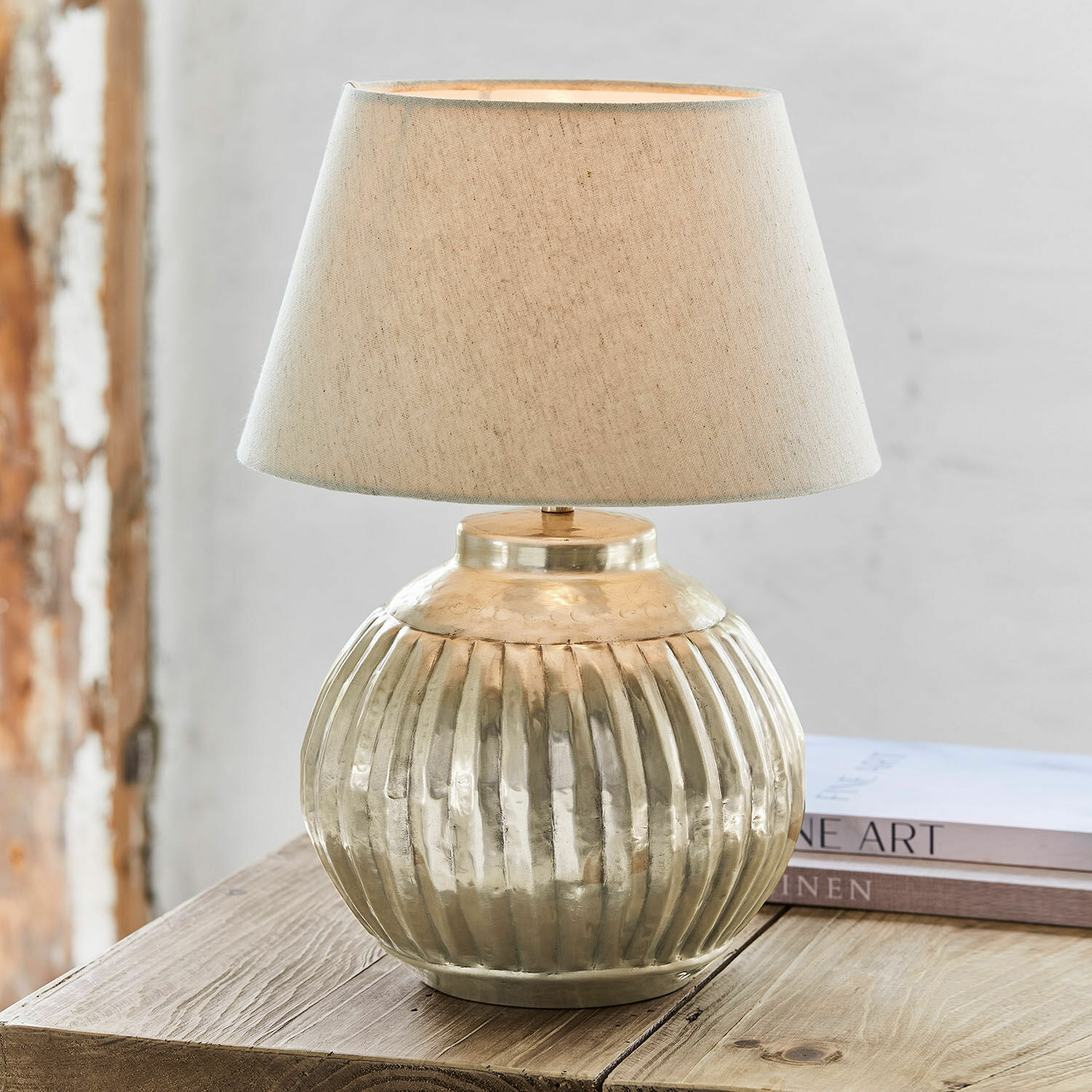 Tafellamp Lillemor Tafellamp van messing met beige kap op houten tafel, interieurdecoratie