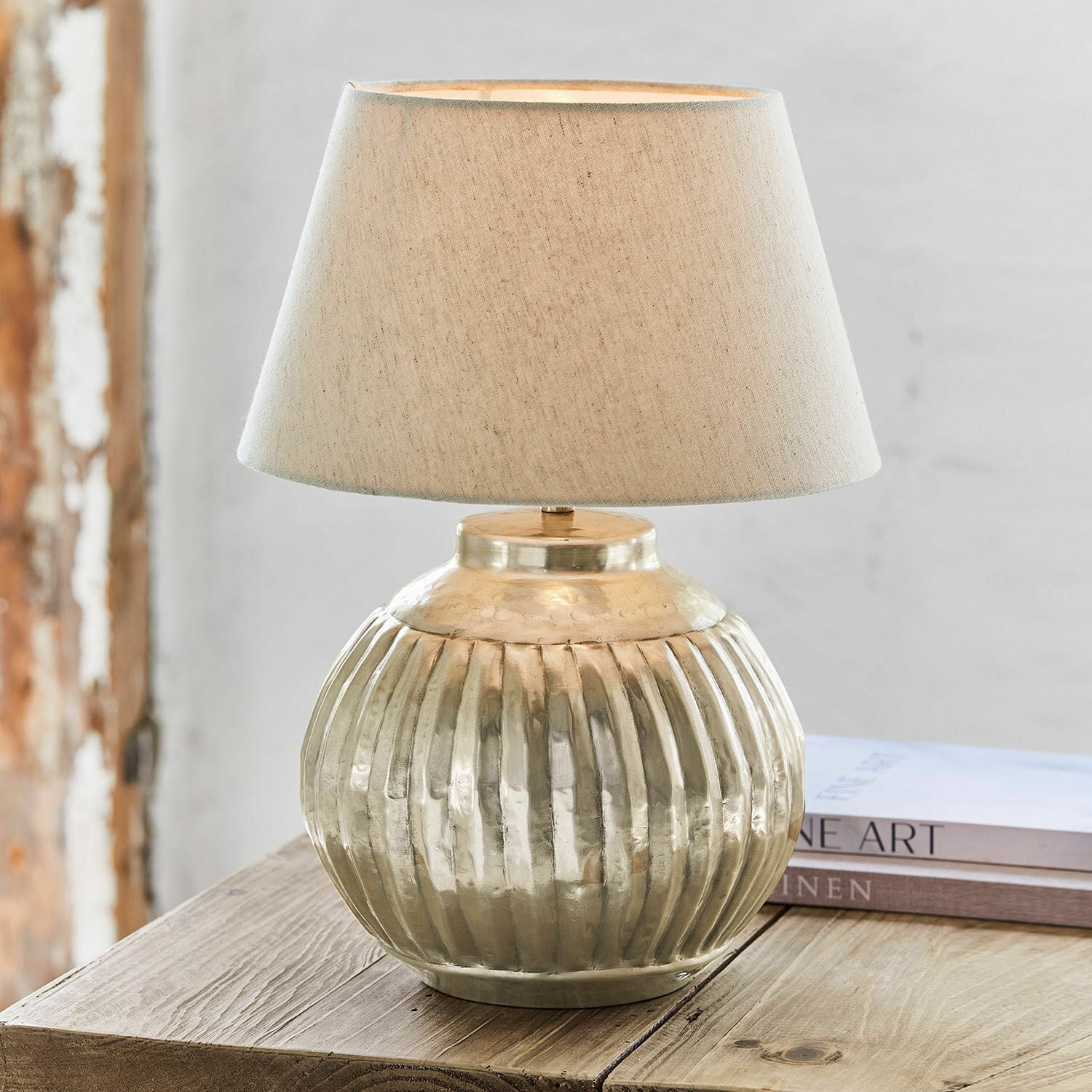 Tafellamp Lillemor Tafellamp van messing met beige kap op houten tafel, interieurdecoratie