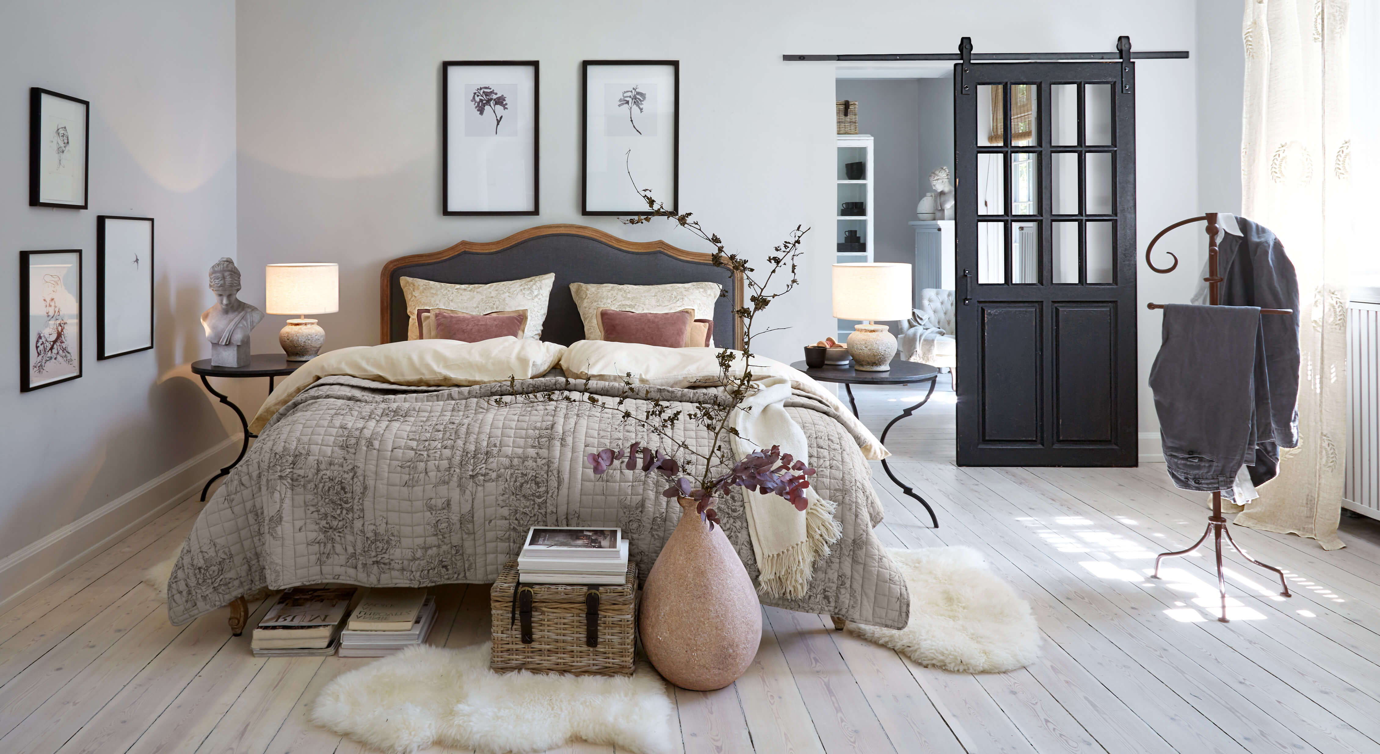 Chambre chaleureuse avec lit en linge gris-beige et tables de chevet noires avec lampes