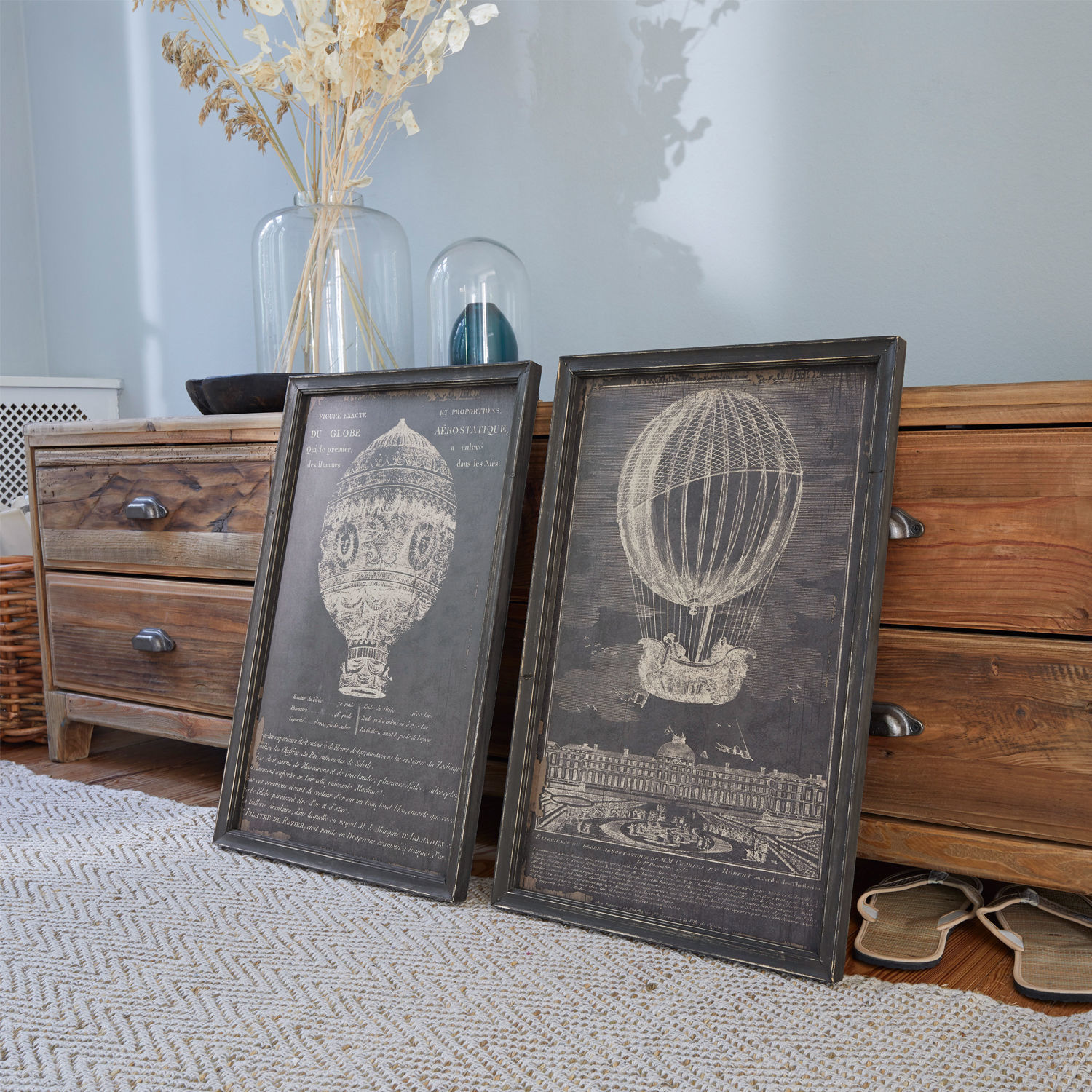 Afbeelding set van 2 Ortarsis Twee zwarte lijsten met luchtballonillustraties op houten vloer naast een ladekast
