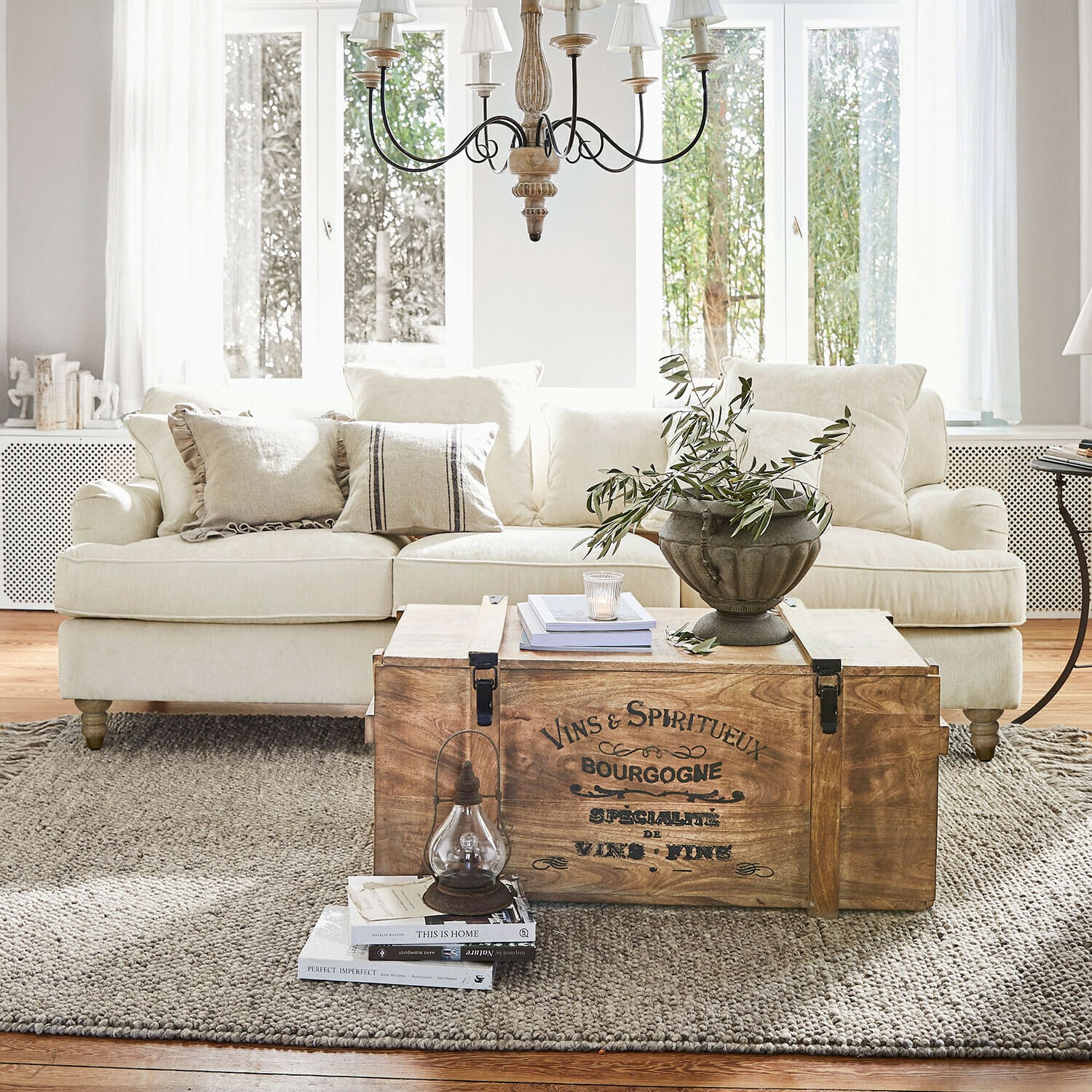 Bank Isa Houten kist met vintage tekst als salontafel in lichte woonkamer met beige bank en decoratie