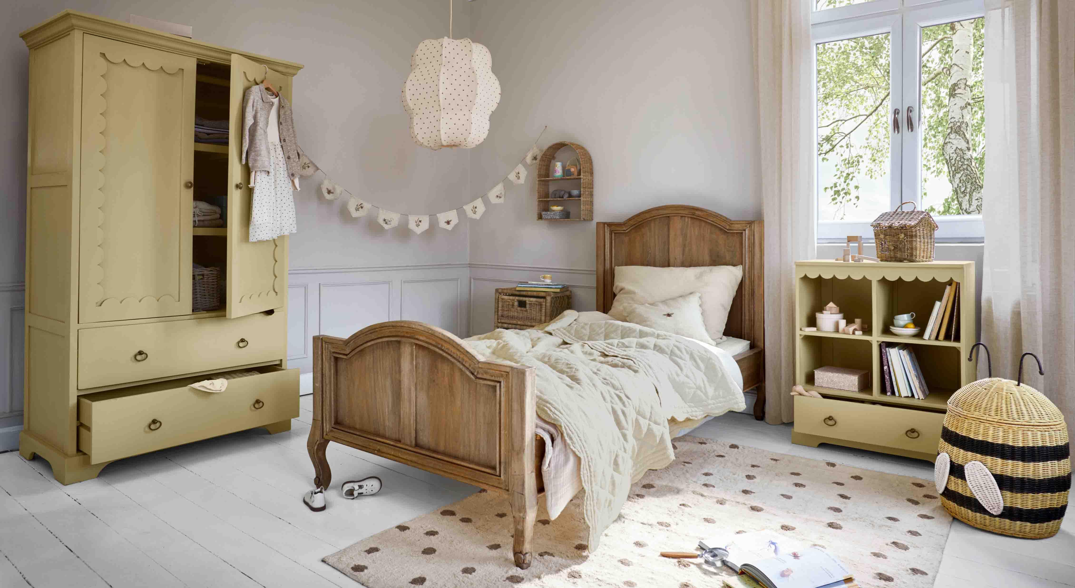 Gezellige kinderkamer met houten bed, gele kast en houten en rieten plank en mand