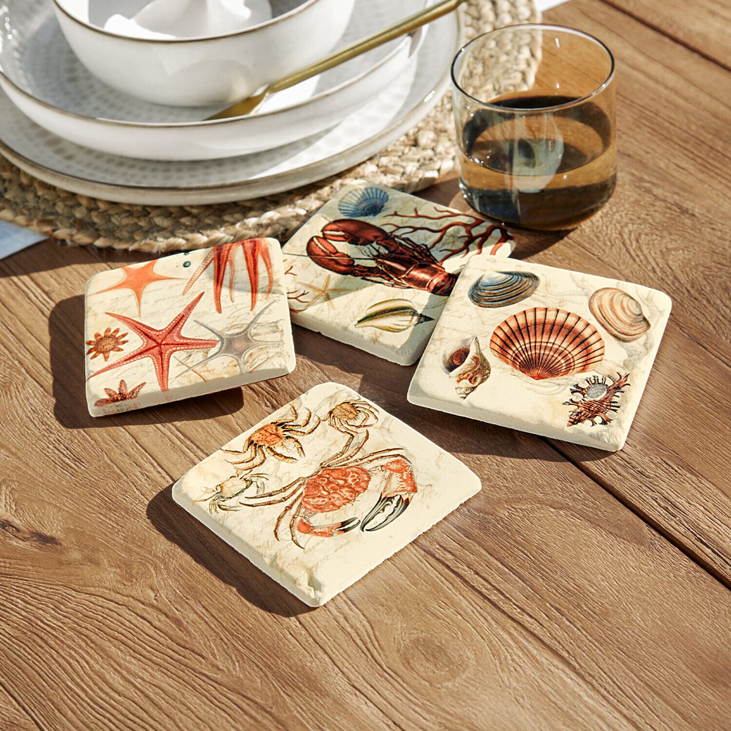Lot de 4 dessous de verres Celorin Ensemble de quatre dessous de verre en céramique avec motifs marins colorés sur une table en bois