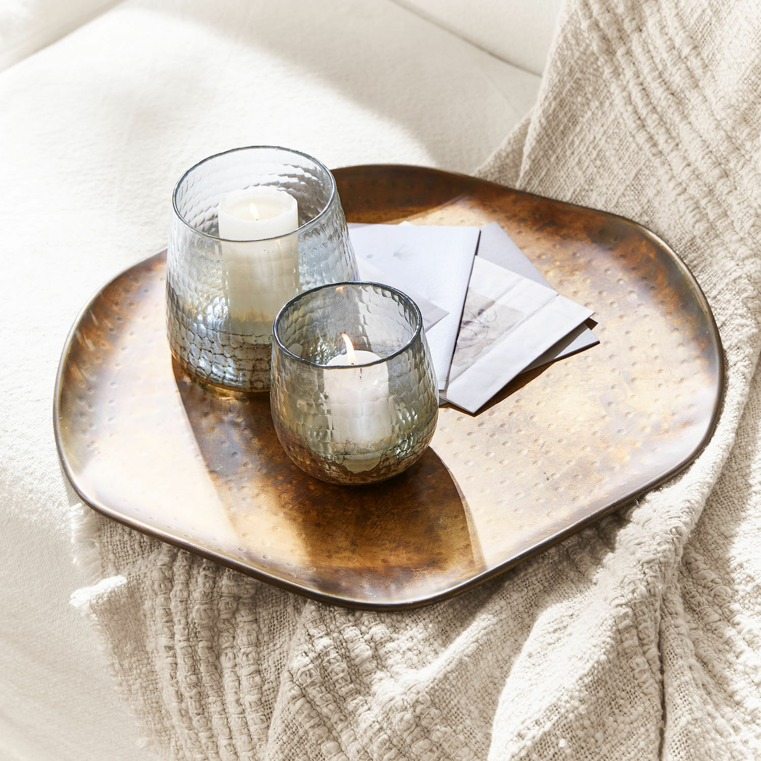 Schaal Frapelle Koperen dienblad met hamerslag, twee glazen windlichten en witte kaarsen erop