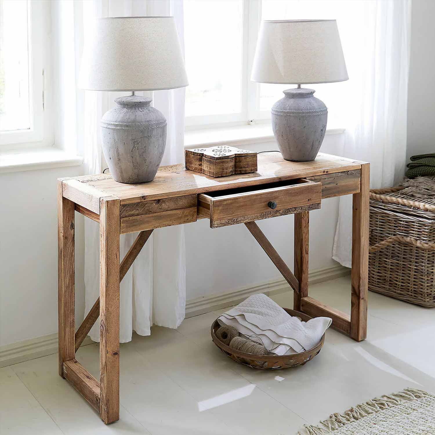 Bureau rustique en bois avec tiroir et deux lampes en céramique grise dans une pièce lumineuse
