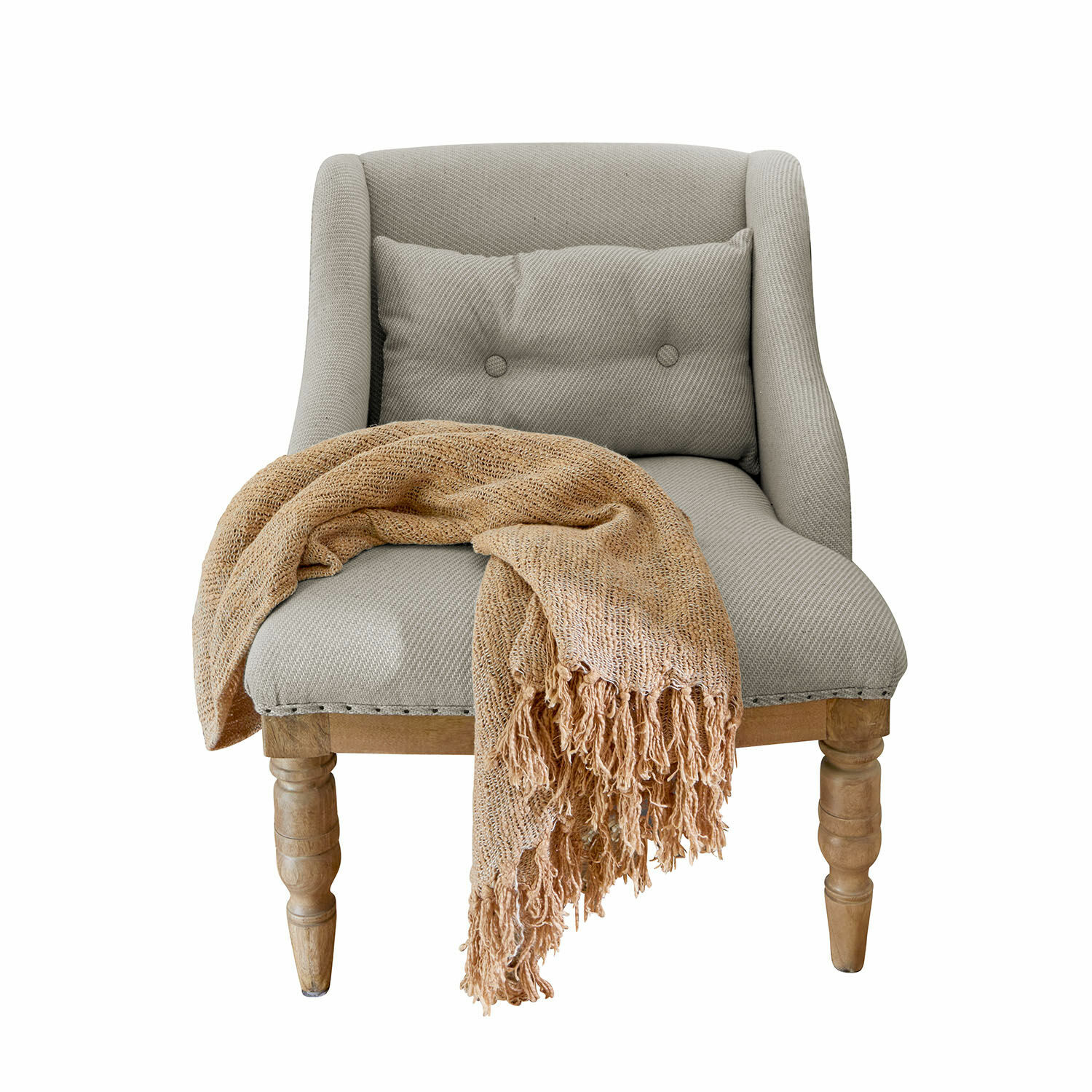 Grijze stoffen fauteuil met houten poten en beige zachte deken op de zitting