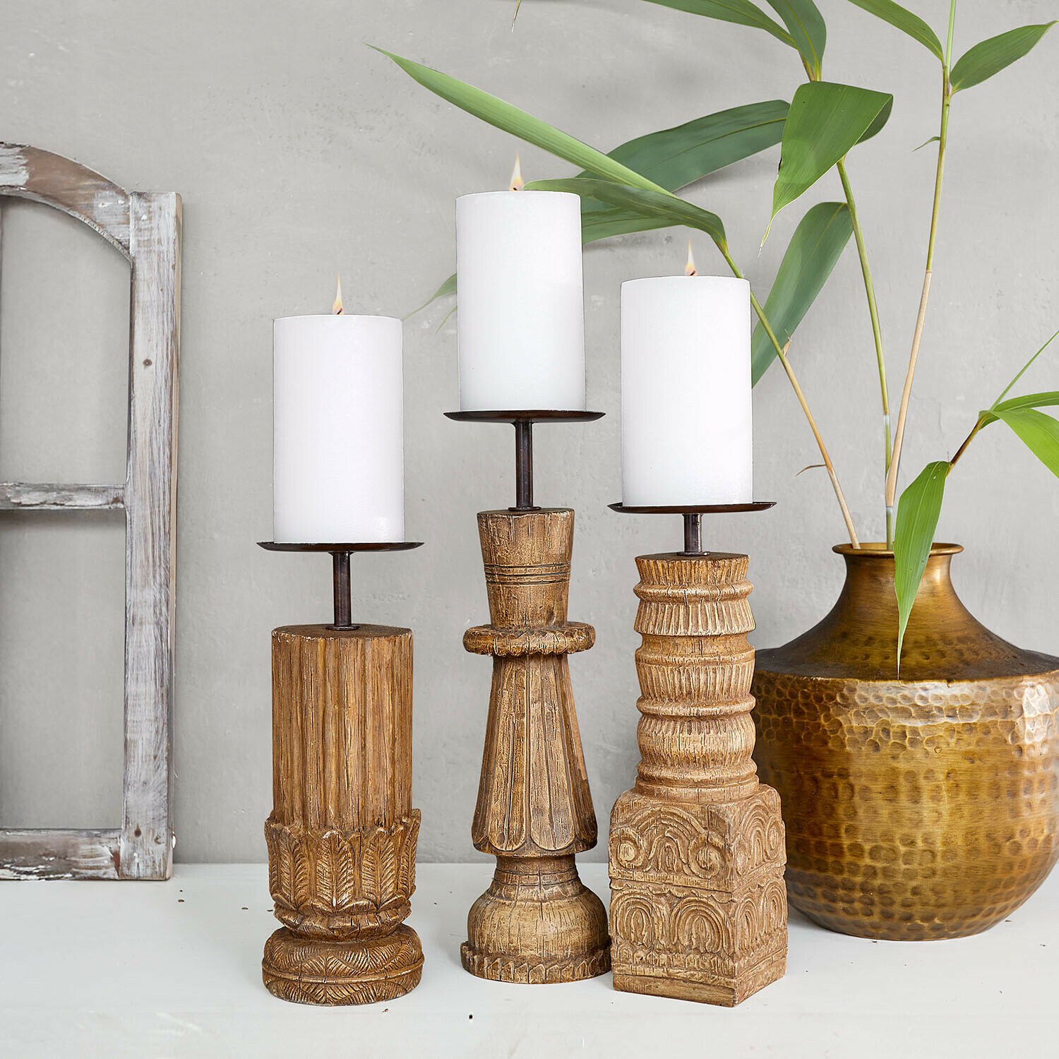 Set van drie houten kandelaren met witte kaarsen, natuurlijke houtkleur en decoratieve patronen