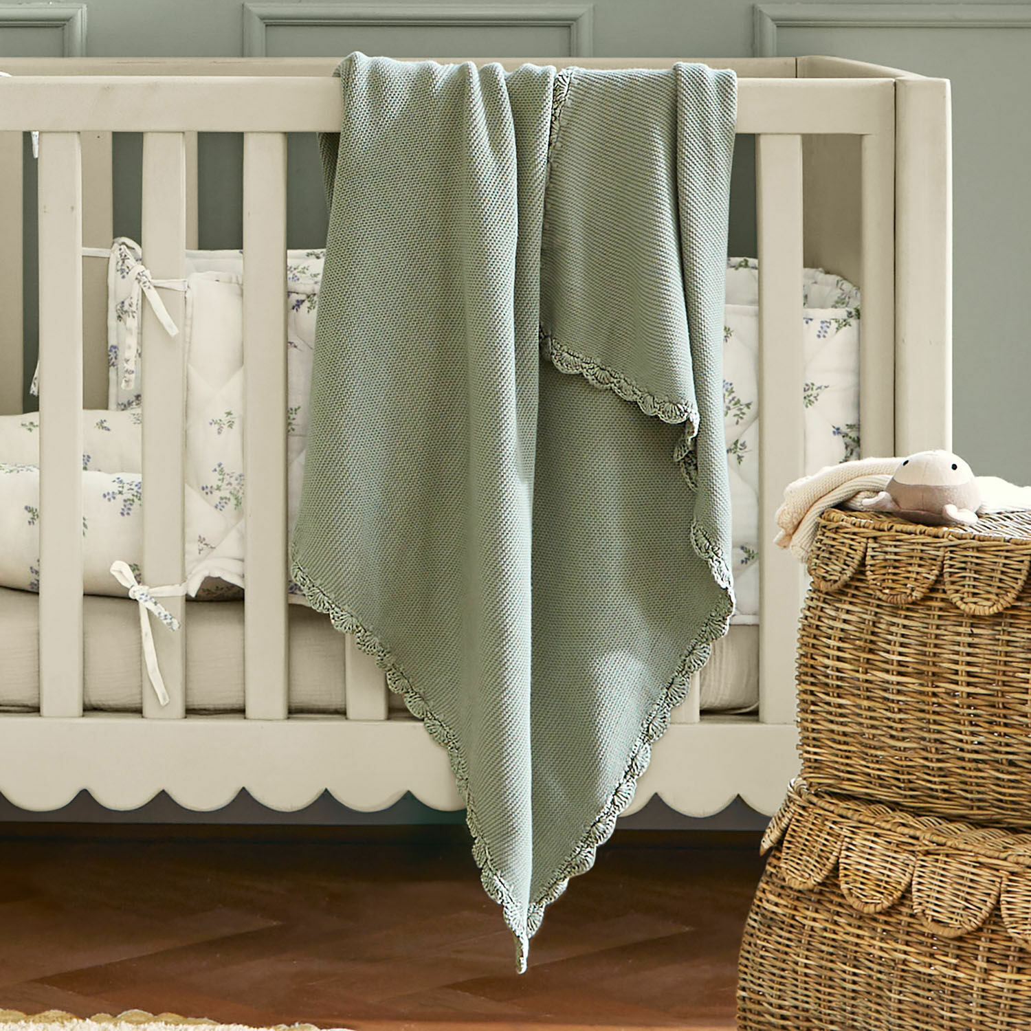 Plaid Nymariel Plaid vert en coton doux avec bordure en dentelle sur un lit bébé beige, décoration chambre enfant