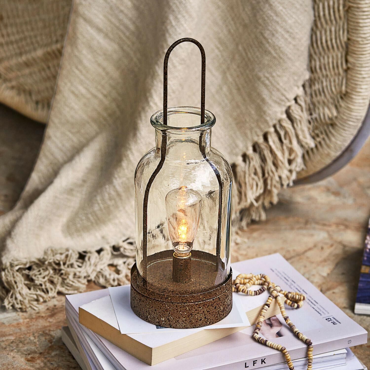 Ledlantaarn Falirah Glazen lantaarn met roestkleurige metalen voet, decoratieve tafellamp op boeken