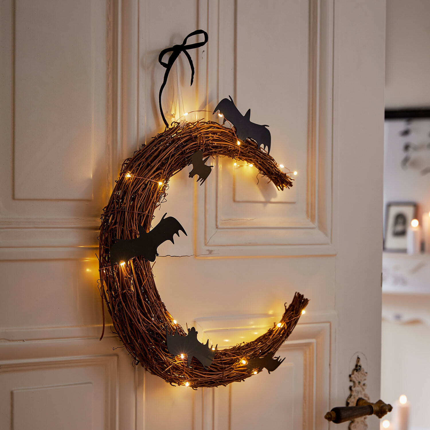 Ledkrans Brynnach Decoratieve krans van takken met zwarte vleermuizen en warme lichtjes aan de deur