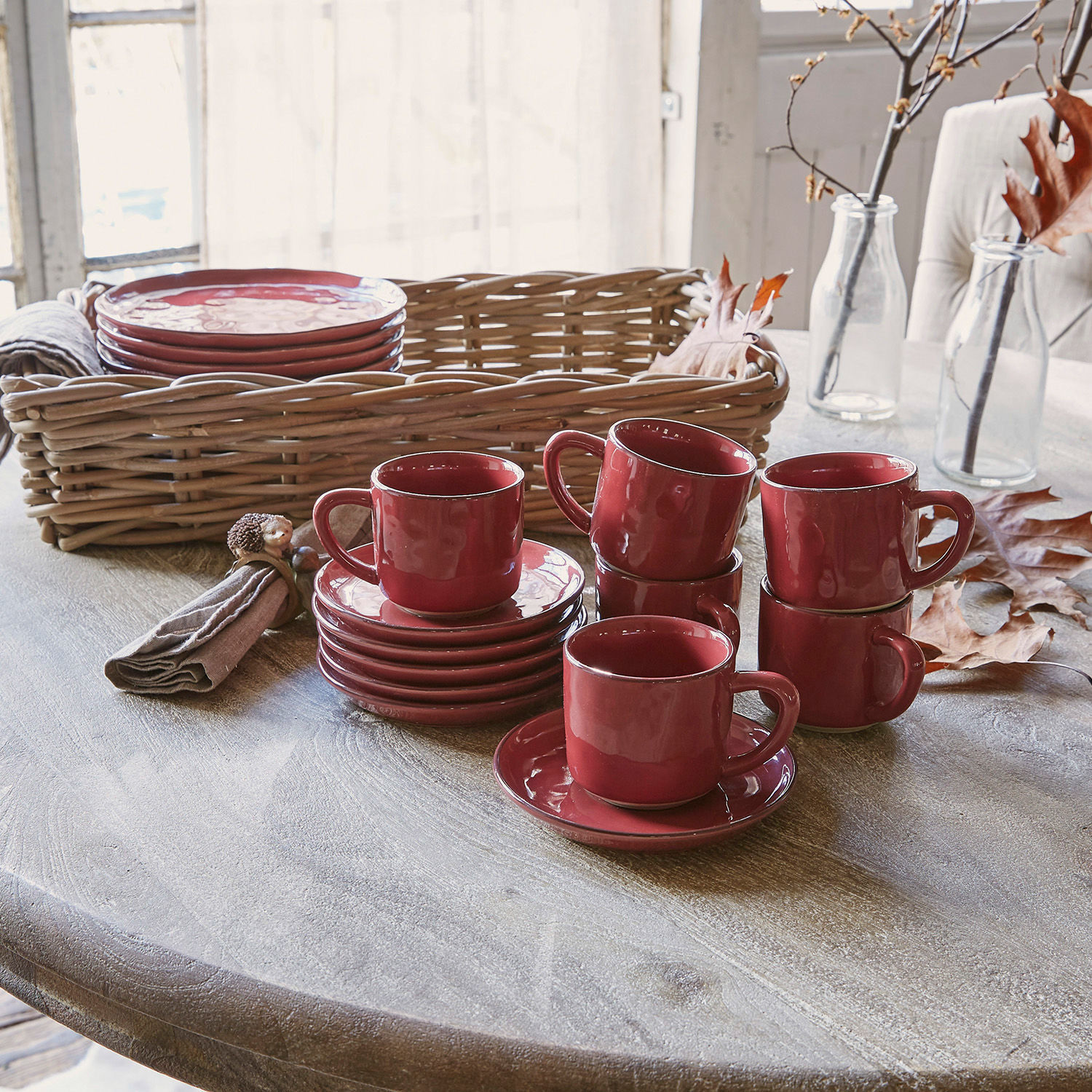 Lot de 6 tasses et soucoupes Biarré Ensemble de tasses et soucoupes en céramique rouge sur table en bois avec panier en osier