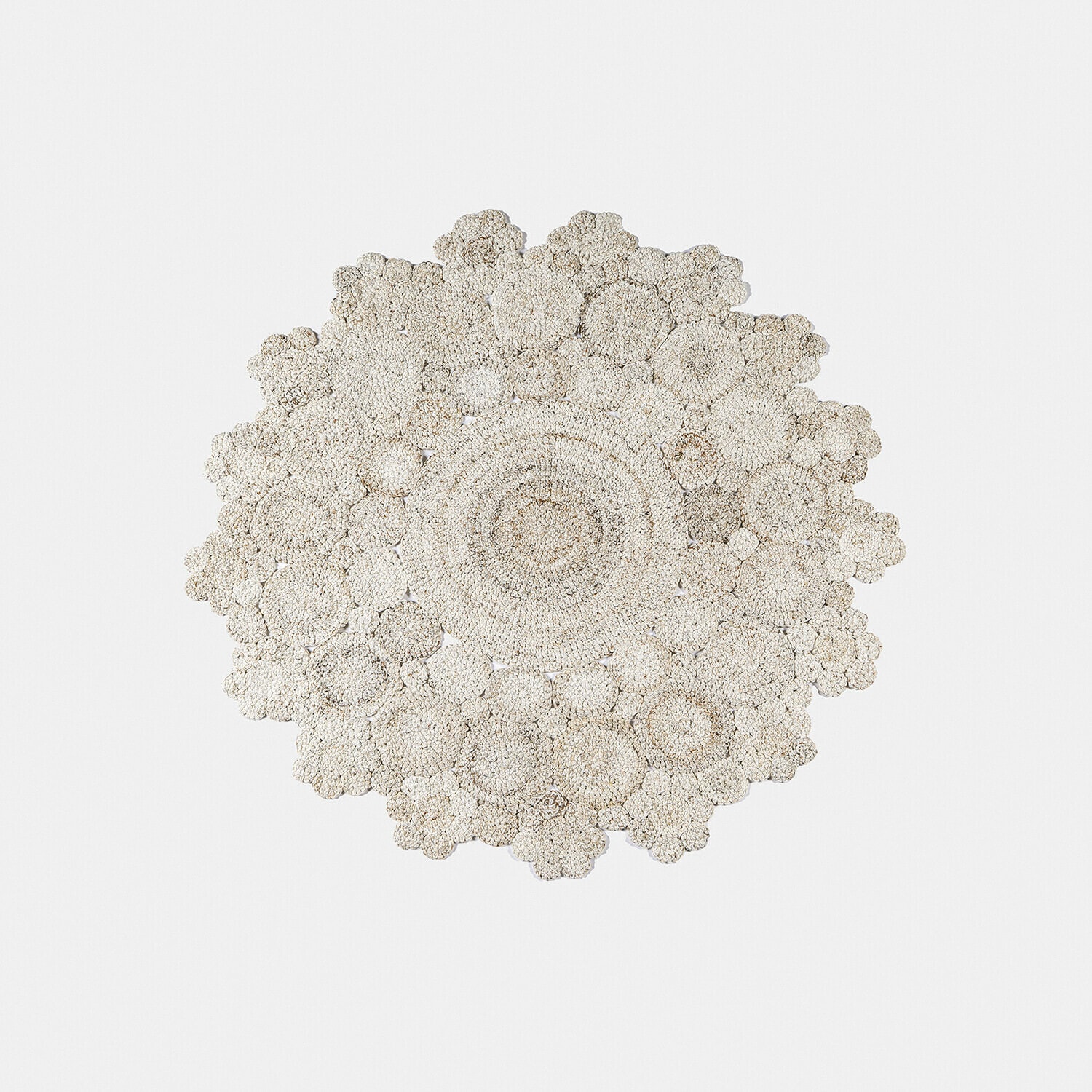 Tapis rond en matériau naturel beige clair avec motif floral, décoration intérieure élégante