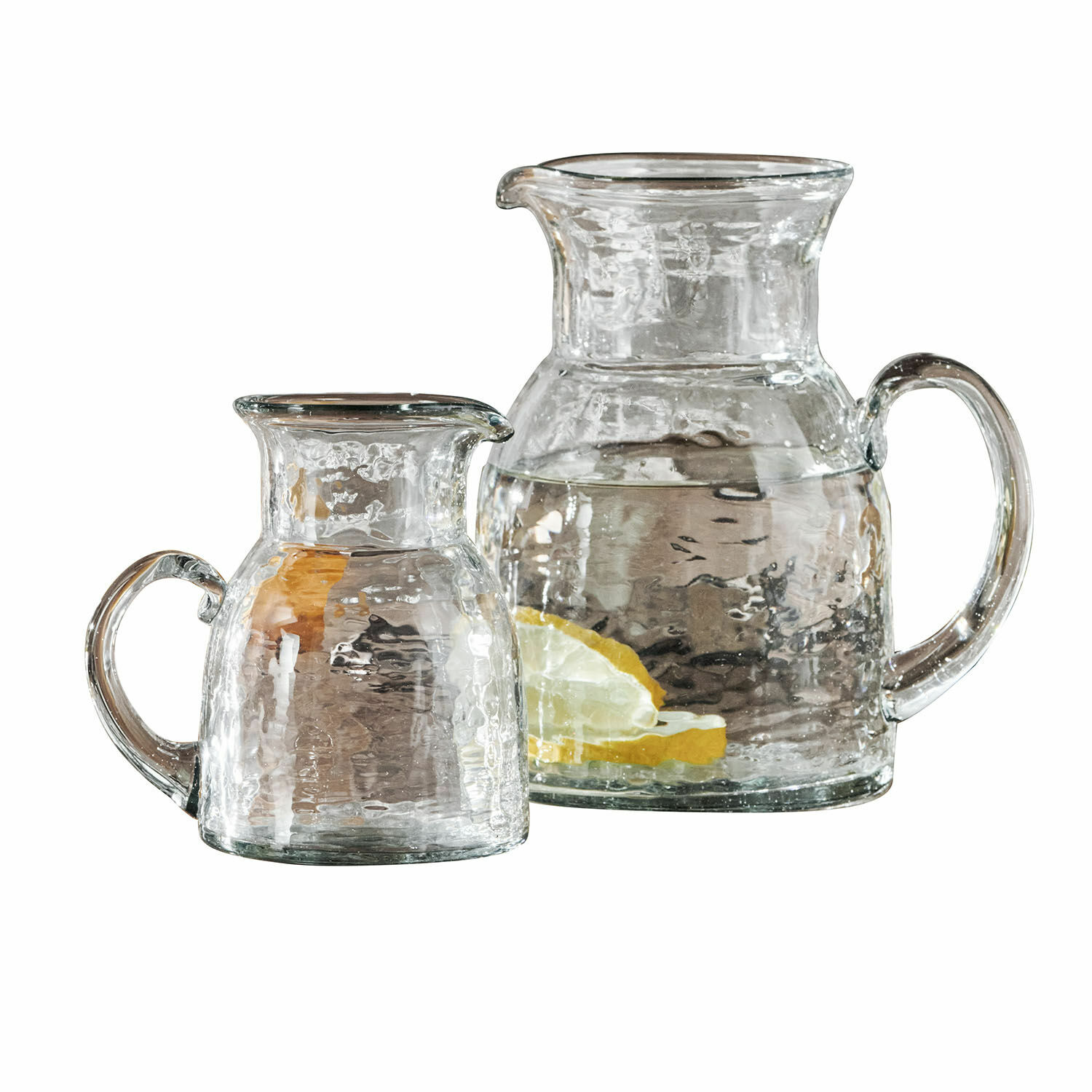 Lot de 2 pichets Zamirah Ensemble de deux pichets en verre transparent avec poignées, un avec tranches de citron et eau