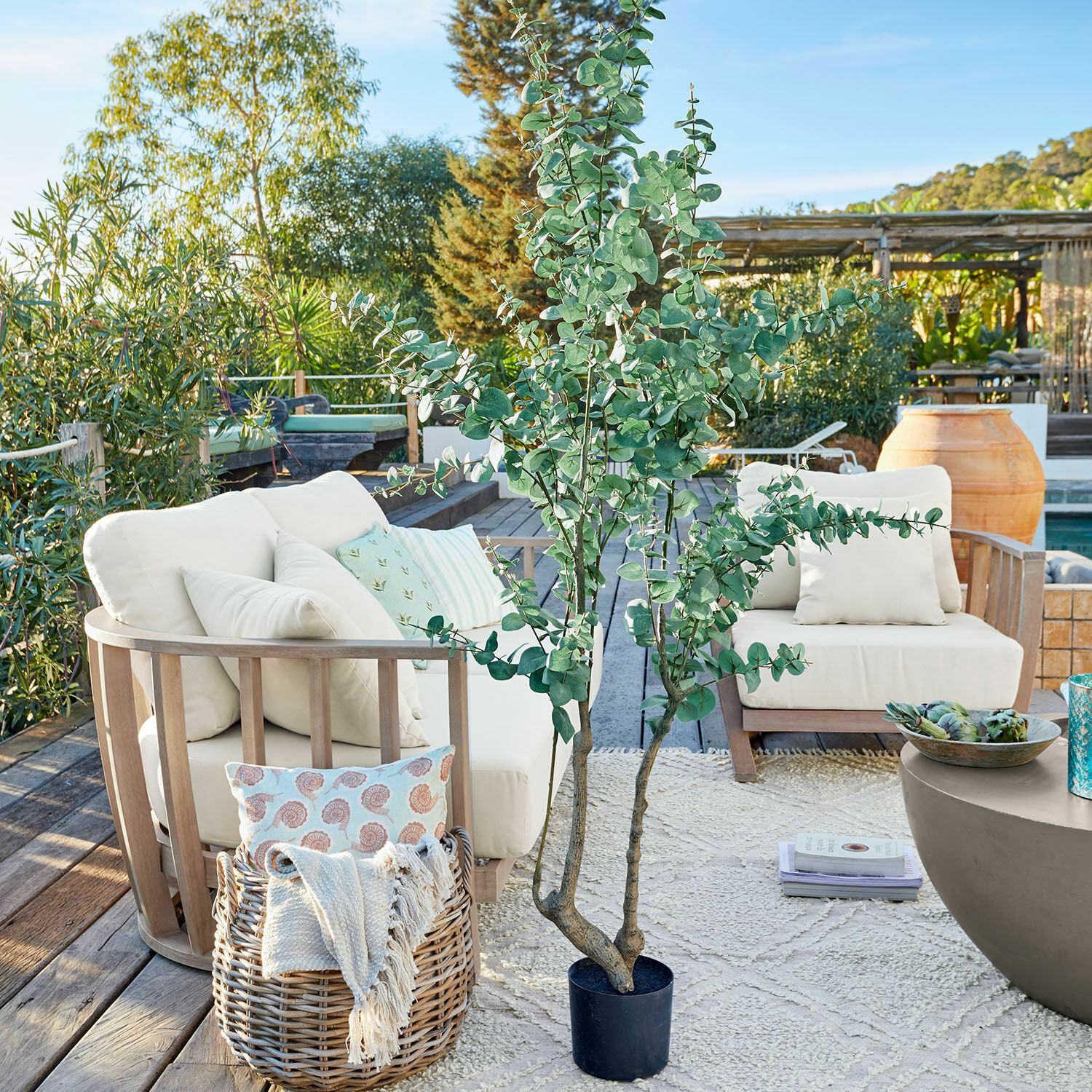 Plante décorative en pot Dorevi Grande plante artificielle d'eucalyptus en pot noir sur terrasse avec mobilier de jardin et décorations