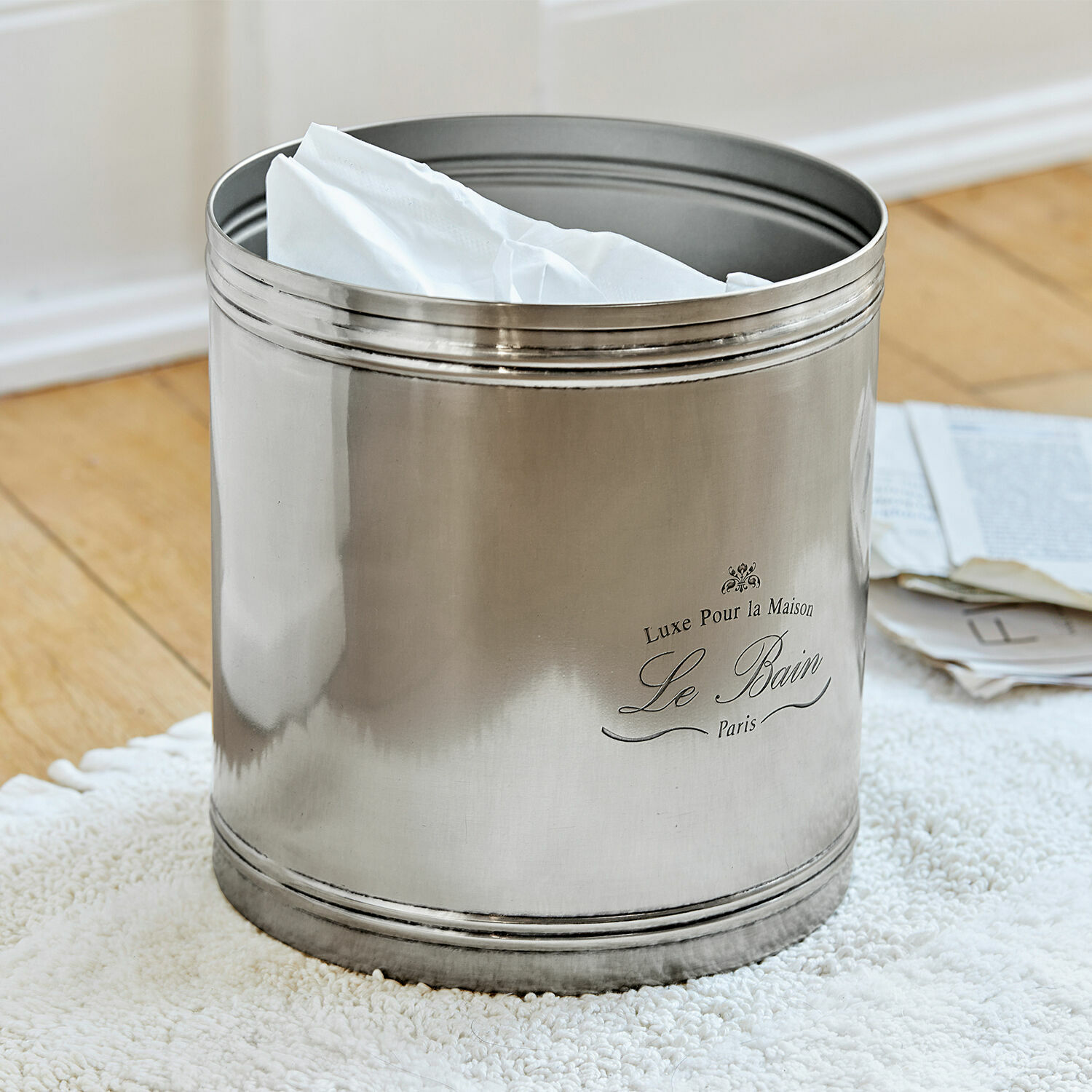 Poubelle de salle de bain en métal argenté avec serviettes blanches, accessoire déco