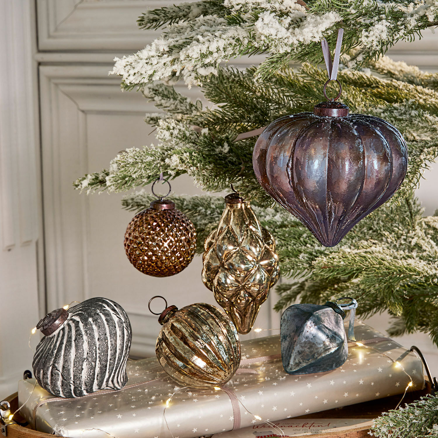 Kerstversiering set van 6 Alva Set glazen kerstballen in bruin- en zilvertinten aan een besneeuwde groene tak