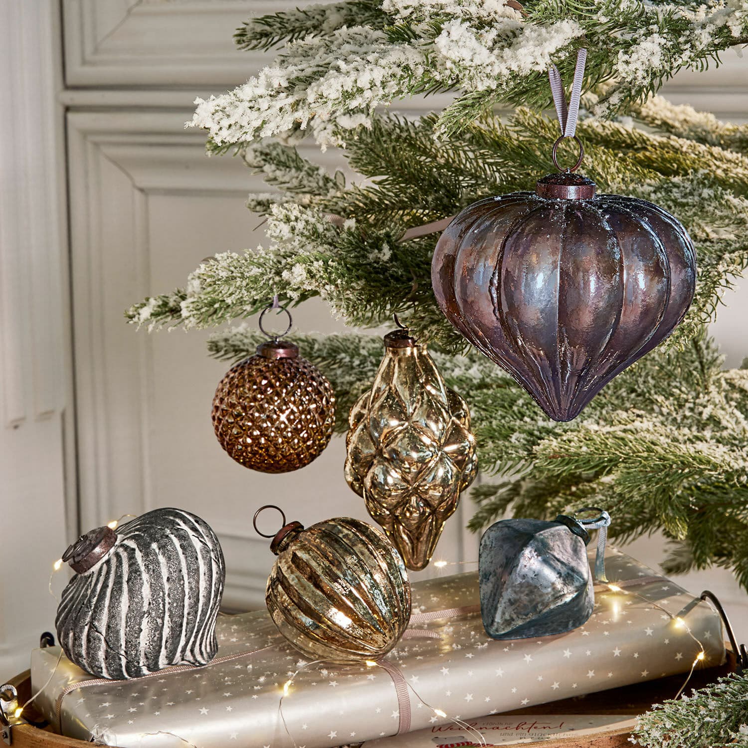 Kerstversiering set van 6 Alva Set glazen kerstballen in bruin- en zilvertinten aan een besneeuwde groene tak