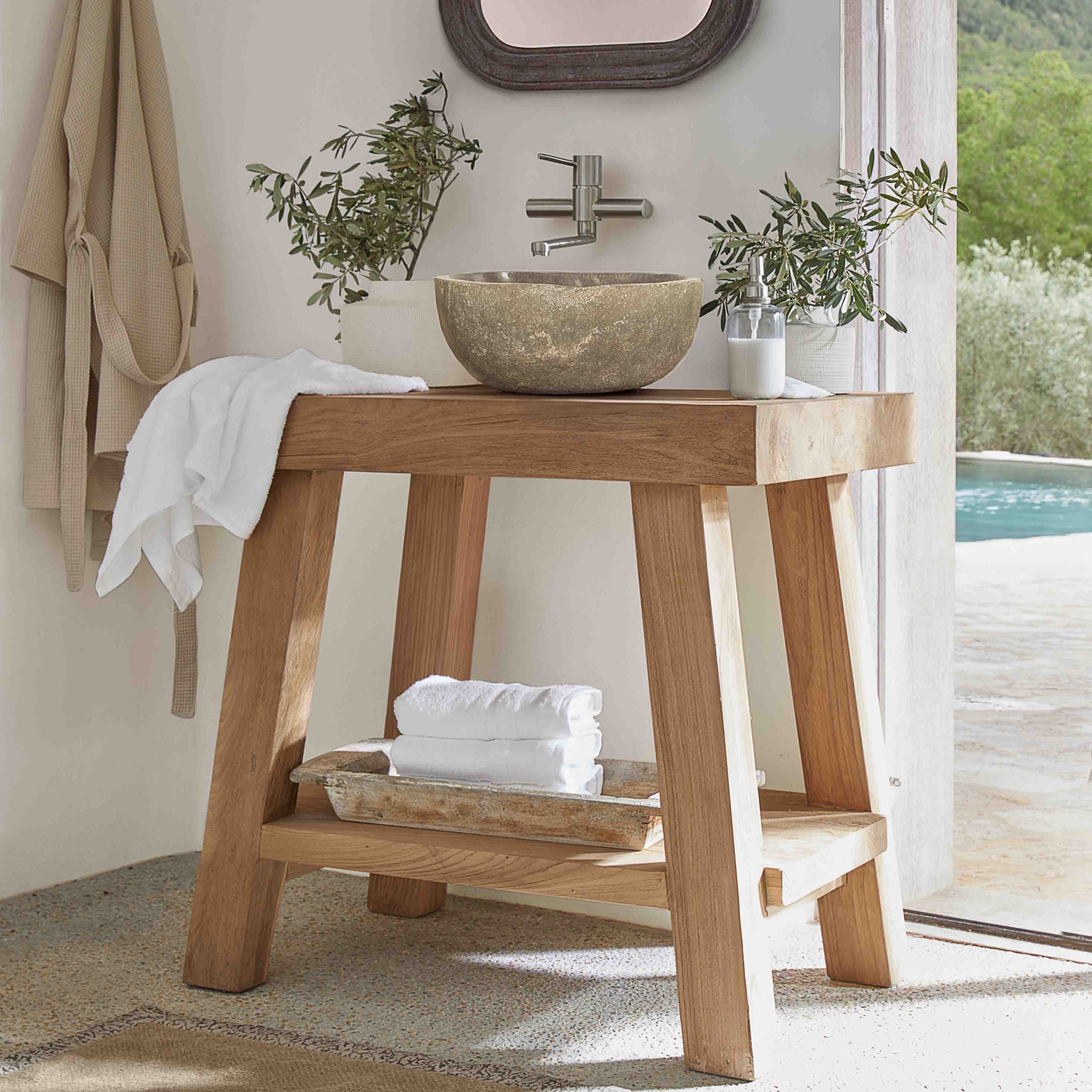 Houten badkamerconsole met stenen waskom en witte handdoeken in lichte ruimte
