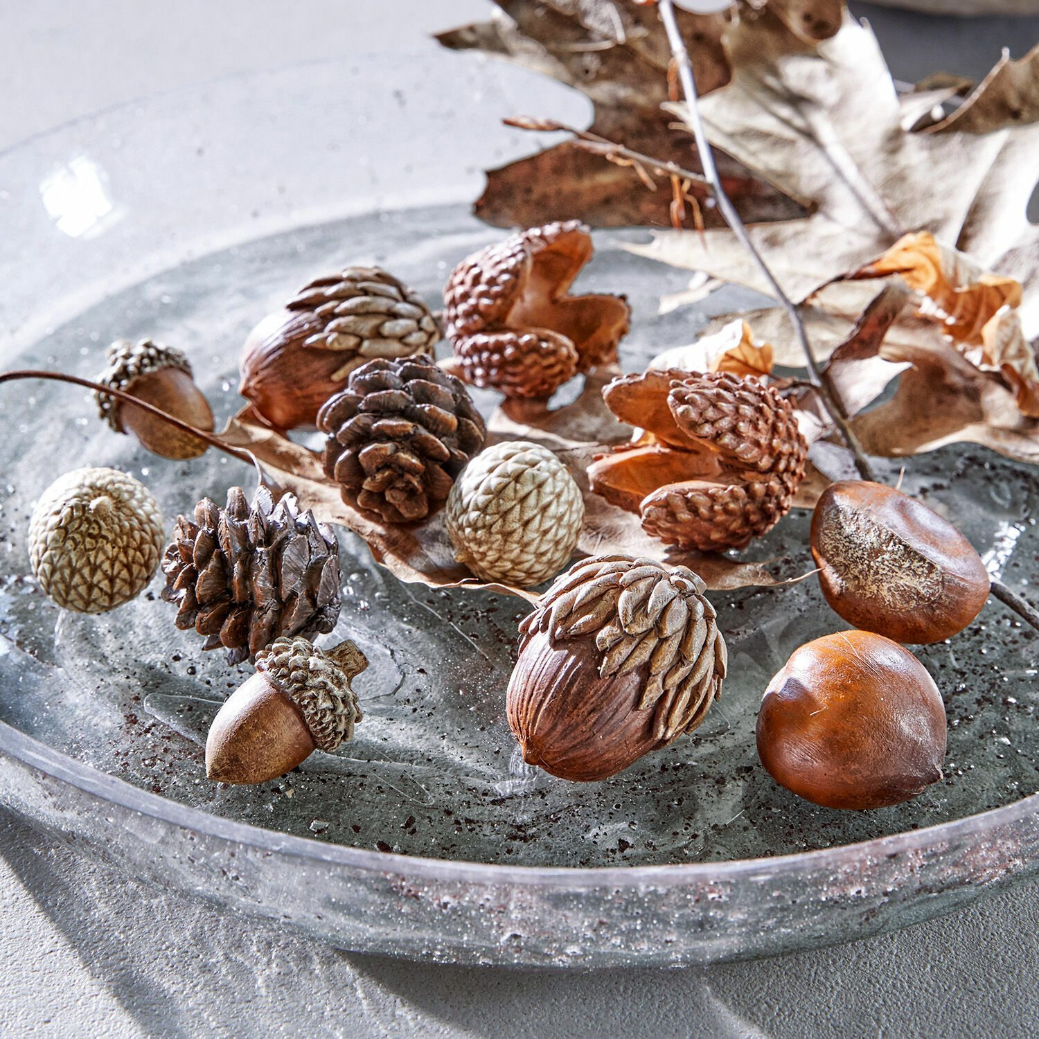 Herfstdecoratie set van 12 Vibius Decoratieve noten en dennenappels in natuurlijke bruine tinten op glazen bord voor herfstdecoratie