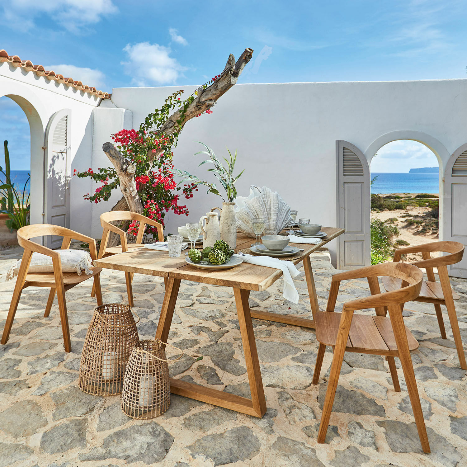 Table Saulny Ensemble de mobilier de jardin en teck avec chaises et table sur patio en pierre face à la mer