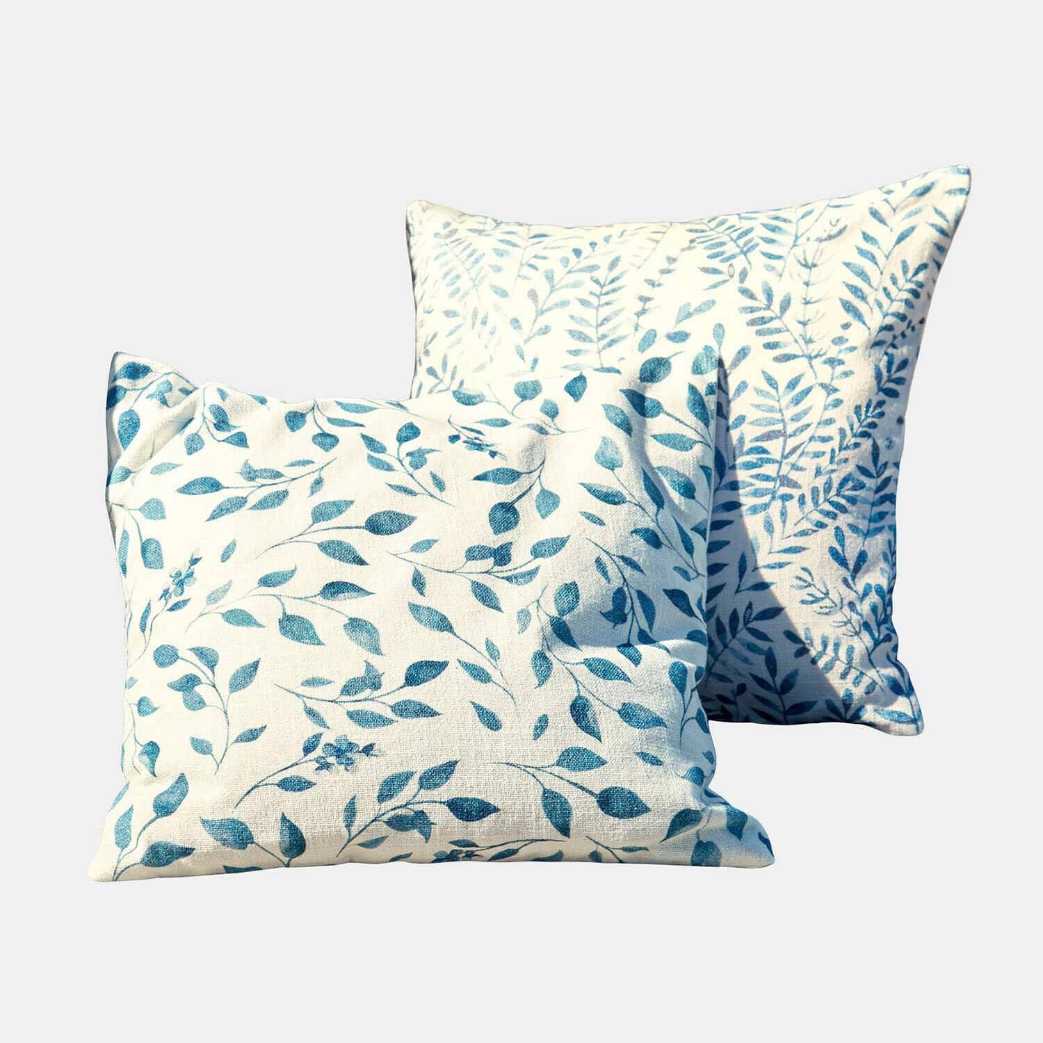 Twee decoratieve katoenen kussens in crème met blauw bladmotief, stijlvolle woontextiel