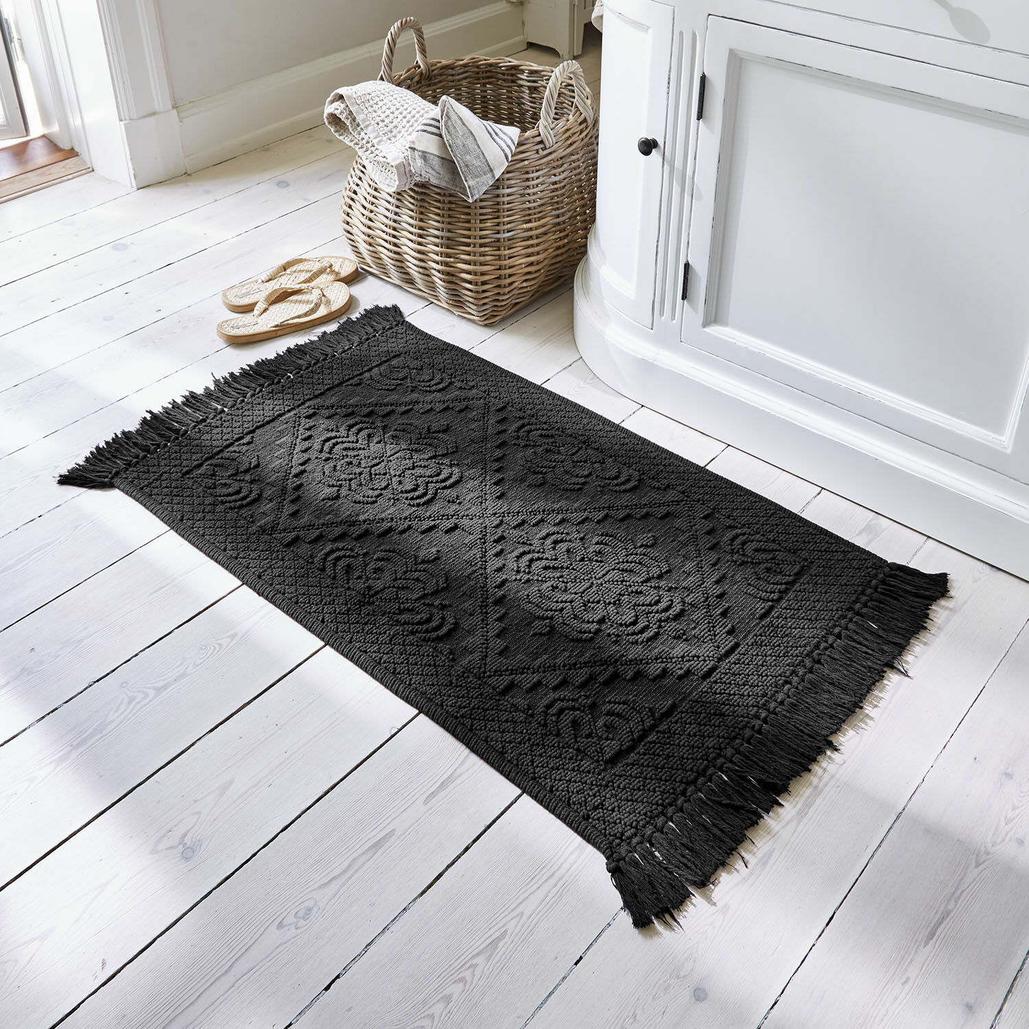 Badmat Mivorex Zwart katoenen vloerkleed met franjes en geometrisch patroon op lichte houten vloer