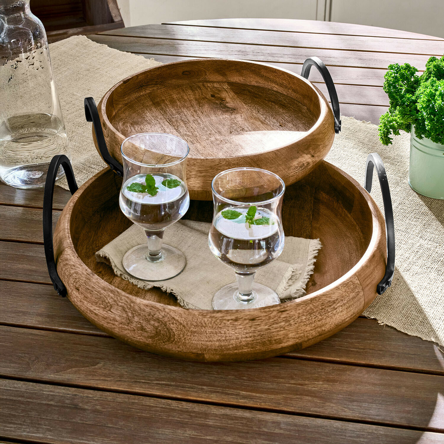 Dienblad set van 2 Arémont Ronde houten dienbladen met metalen handvatten op houten tafel met twee glazen water met munt