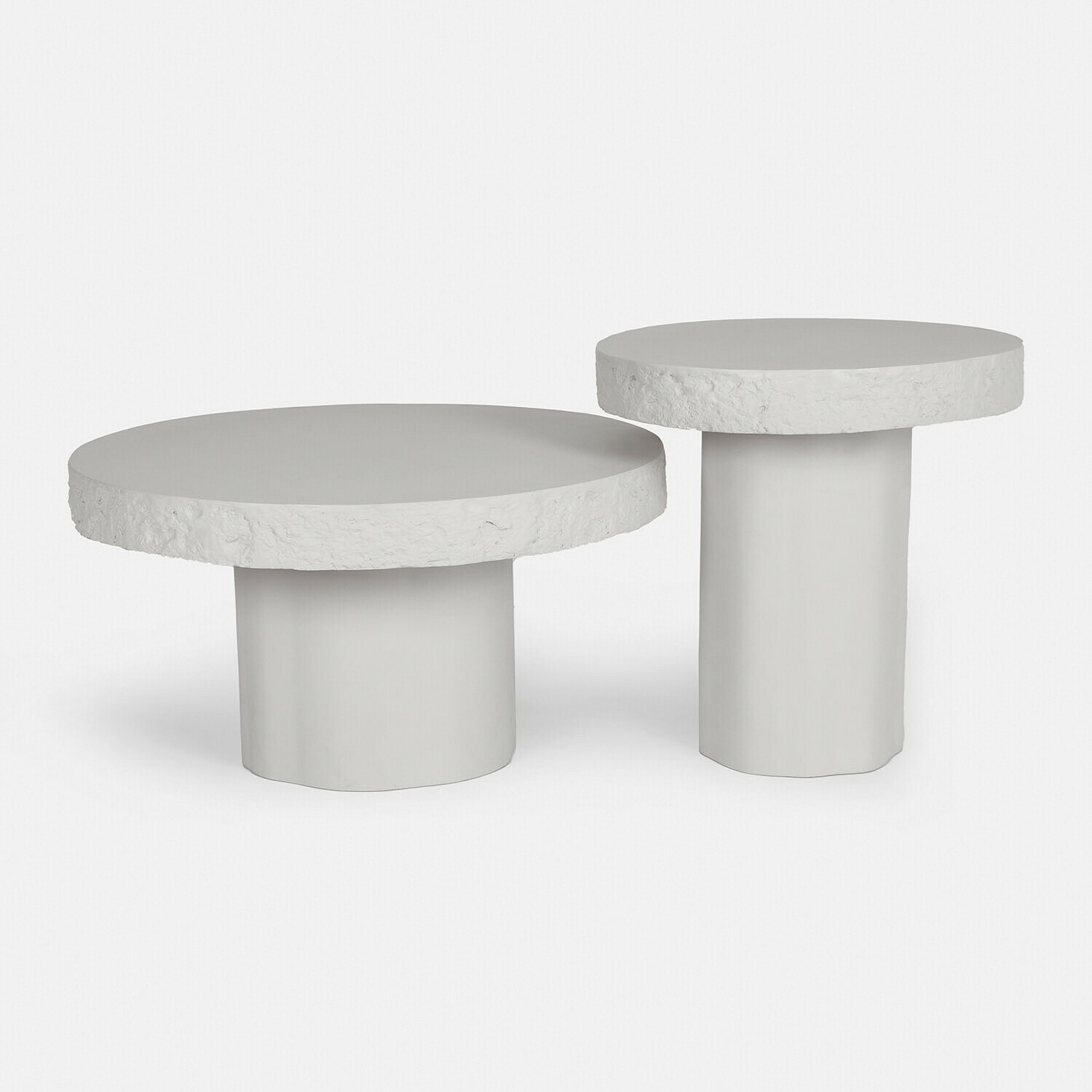 Set van twee witte betonnen salontafels met gestructureerd blad en cilindervormige voet