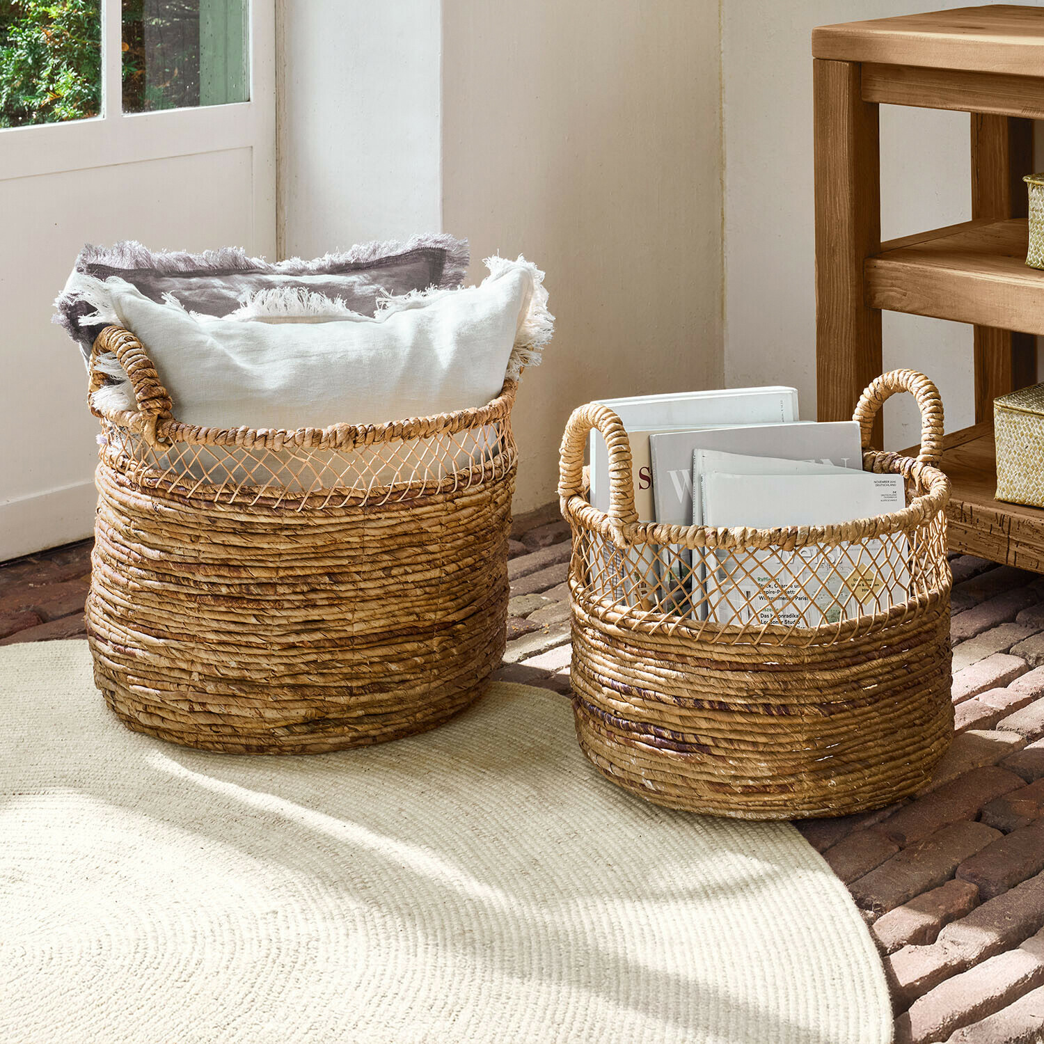 Lot de 2 paniers Dorelin Deux paniers en osier naturel avec poignées, remplis de coussins et de livres pour rangement décoratif