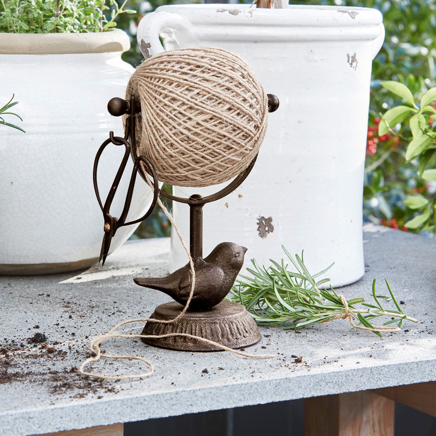 Dévidoir à ficelle Ortolan Support en métal brun avec pelote de ficelle, ciseaux et oiseau décoratif sur table extérieure
