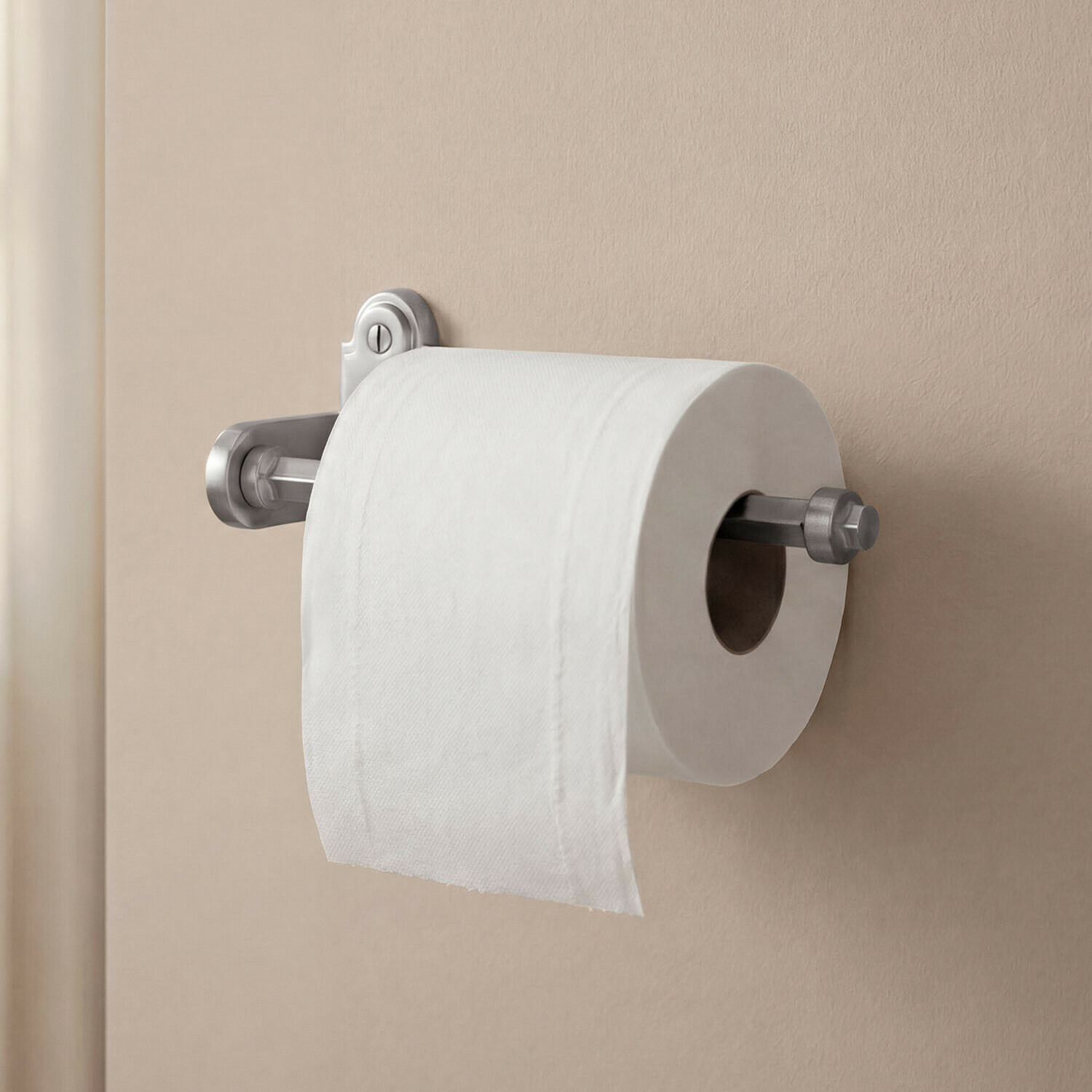 Toiletrolhouder Virellane Metalen zilveren toiletrolhouder gemonteerd op een beige muur in de badkamer