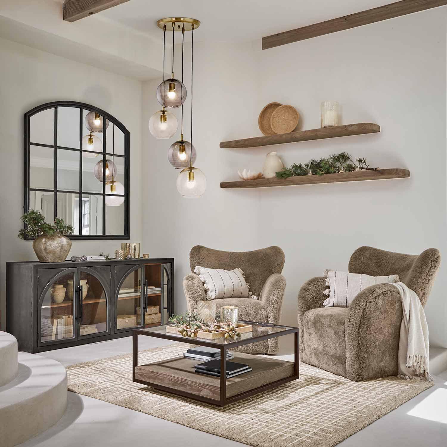 Salon chaleureux avec deux fauteuils marron en tissu doux et une table basse en bois et métal