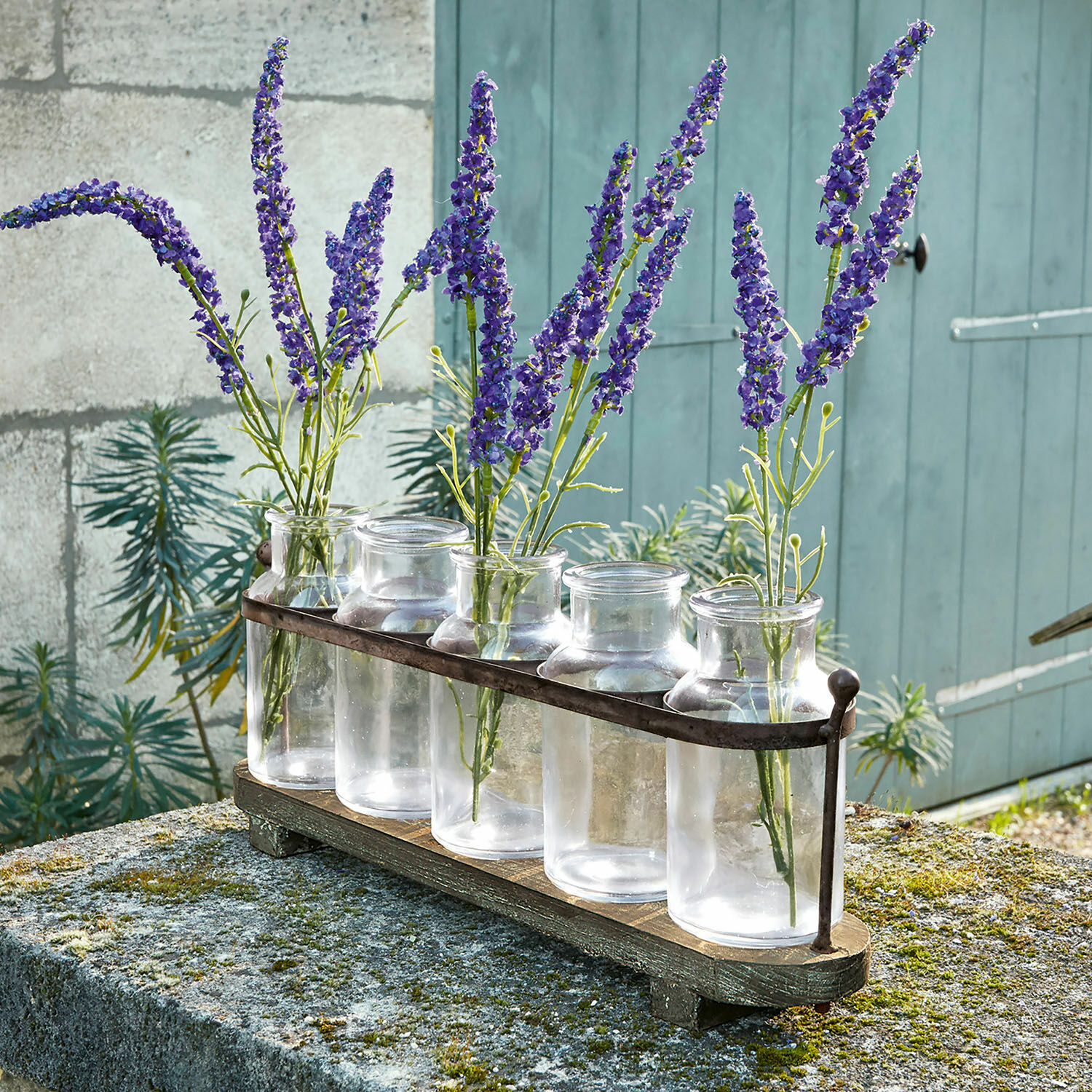 Vaasje set van 5 Ranjo Set van vijf doorzichtige glazen vazen met metalen houder op houten voet met paarse bloemen