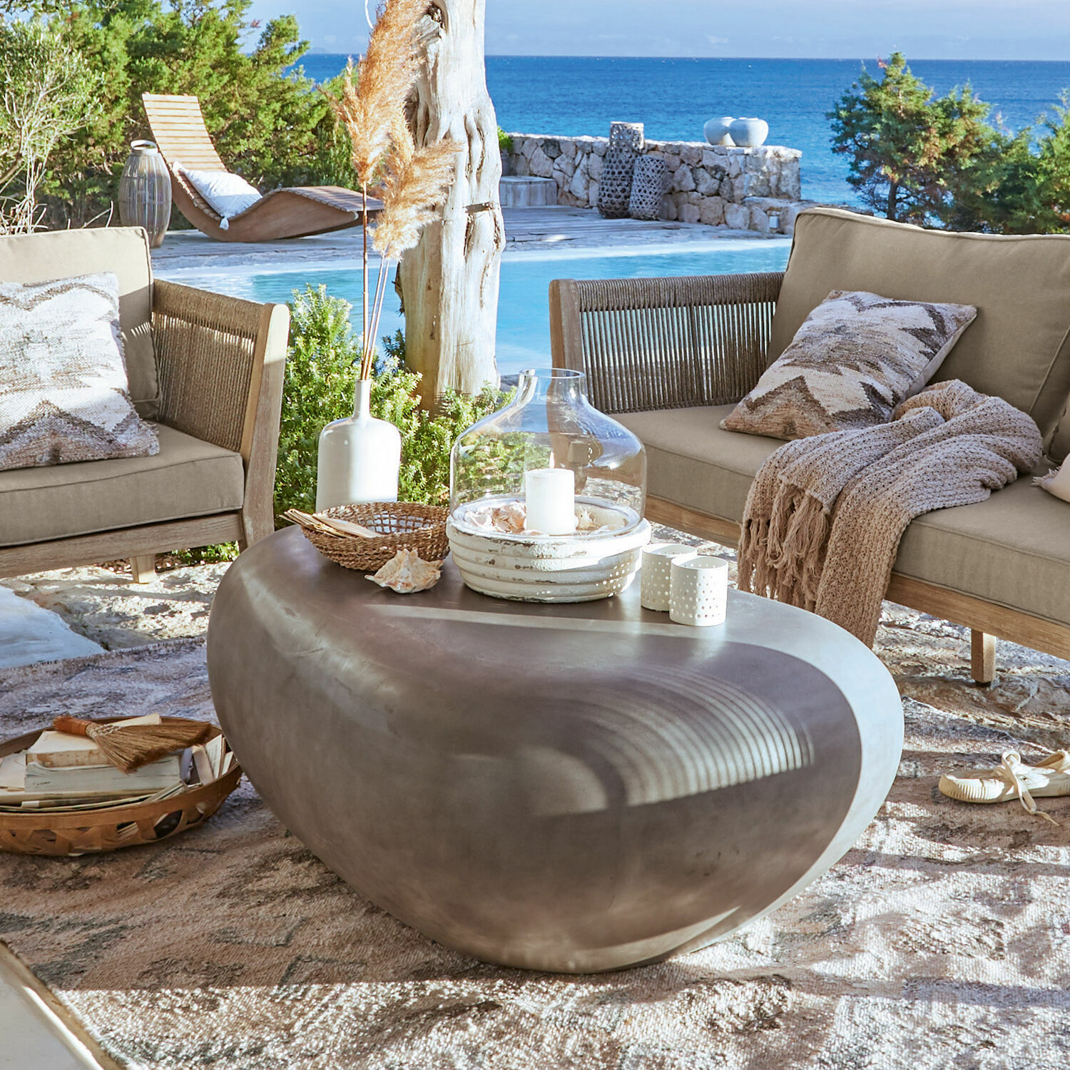 Table basse Fermline Table basse moderne en béton en forme de pierre sur terrasse avec vue sur la mer