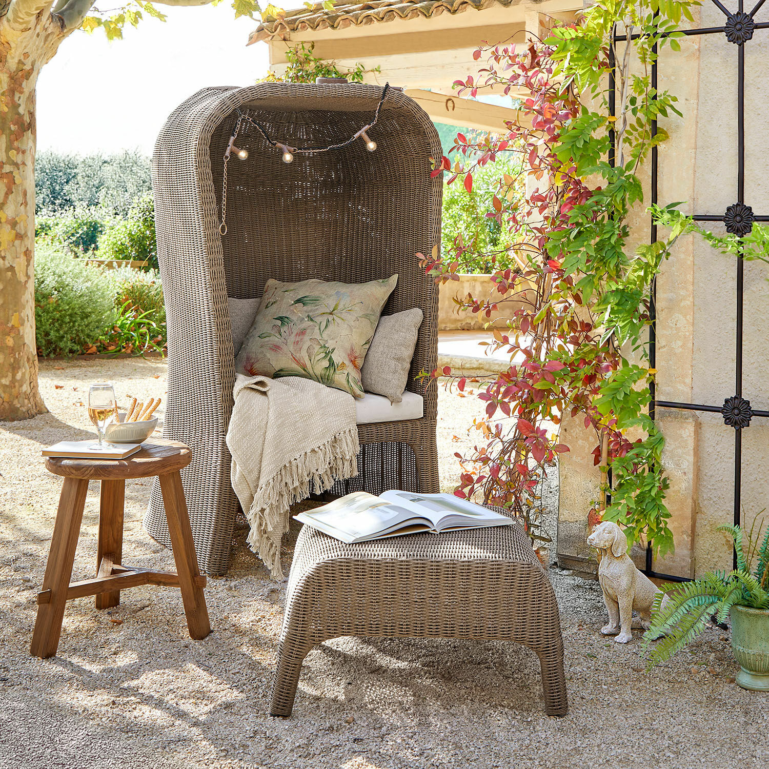 Corbeille de plage avec repose-pieds Sanivane Fauteuil en rotin gris avec coussins et plaid, table en bois et pouf avec livre en extérieur