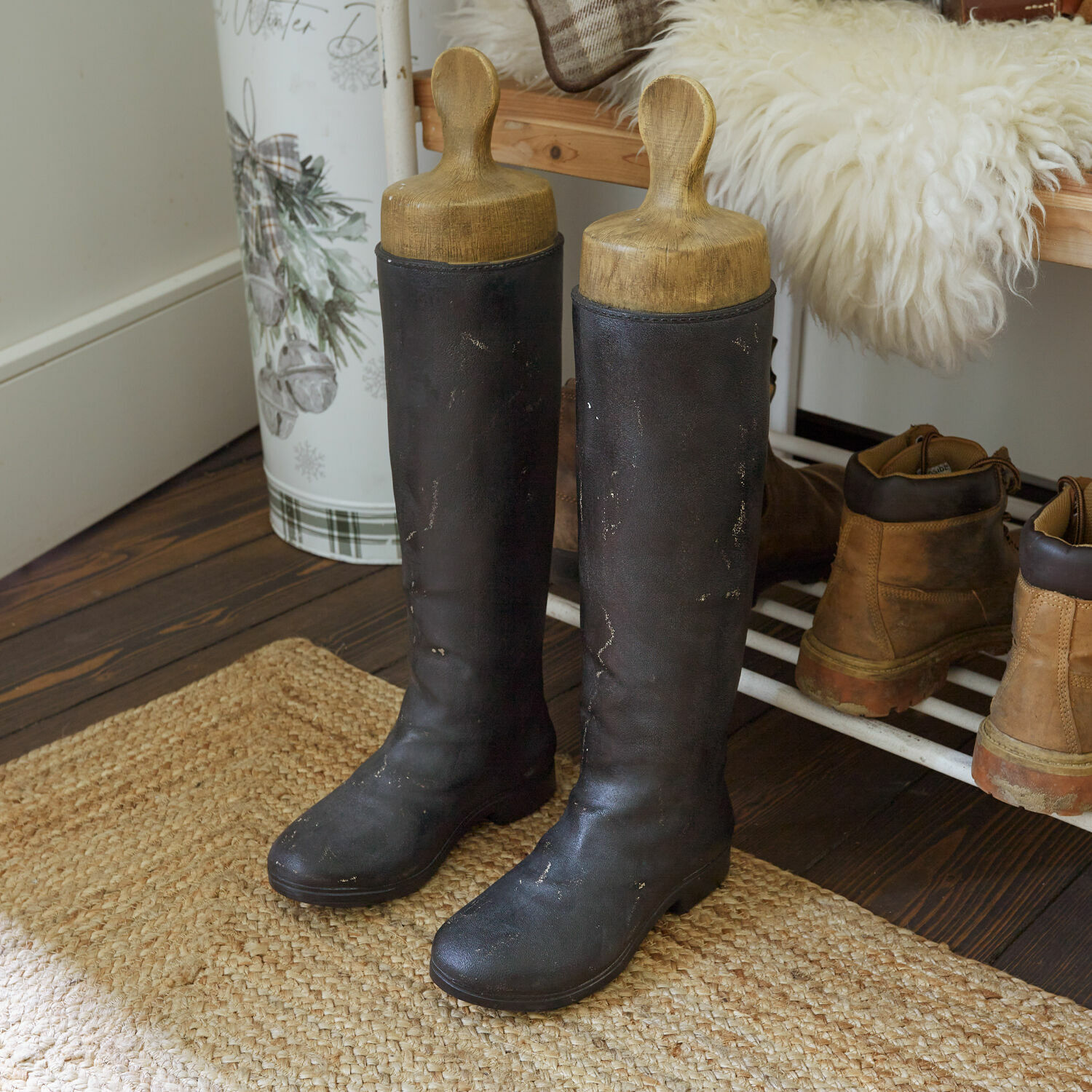 Bottes décoratives Marnivaux Bottes hautes en cuir noir avec embauchoirs en bois sur un tapis dans une entrée rustique
