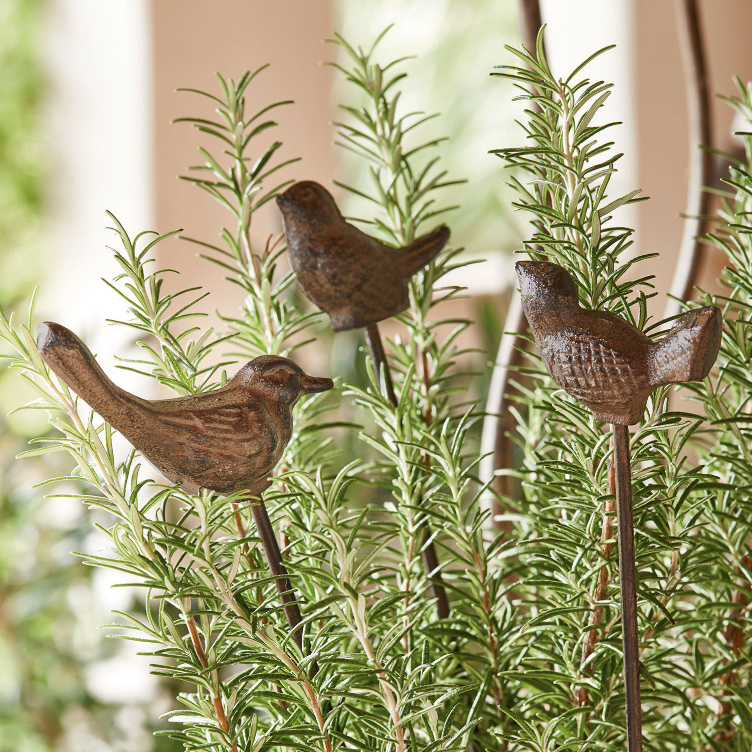 Oiseaux décoratifs en métal brun sur tiges plantés dans des plantes vertes pour jardin