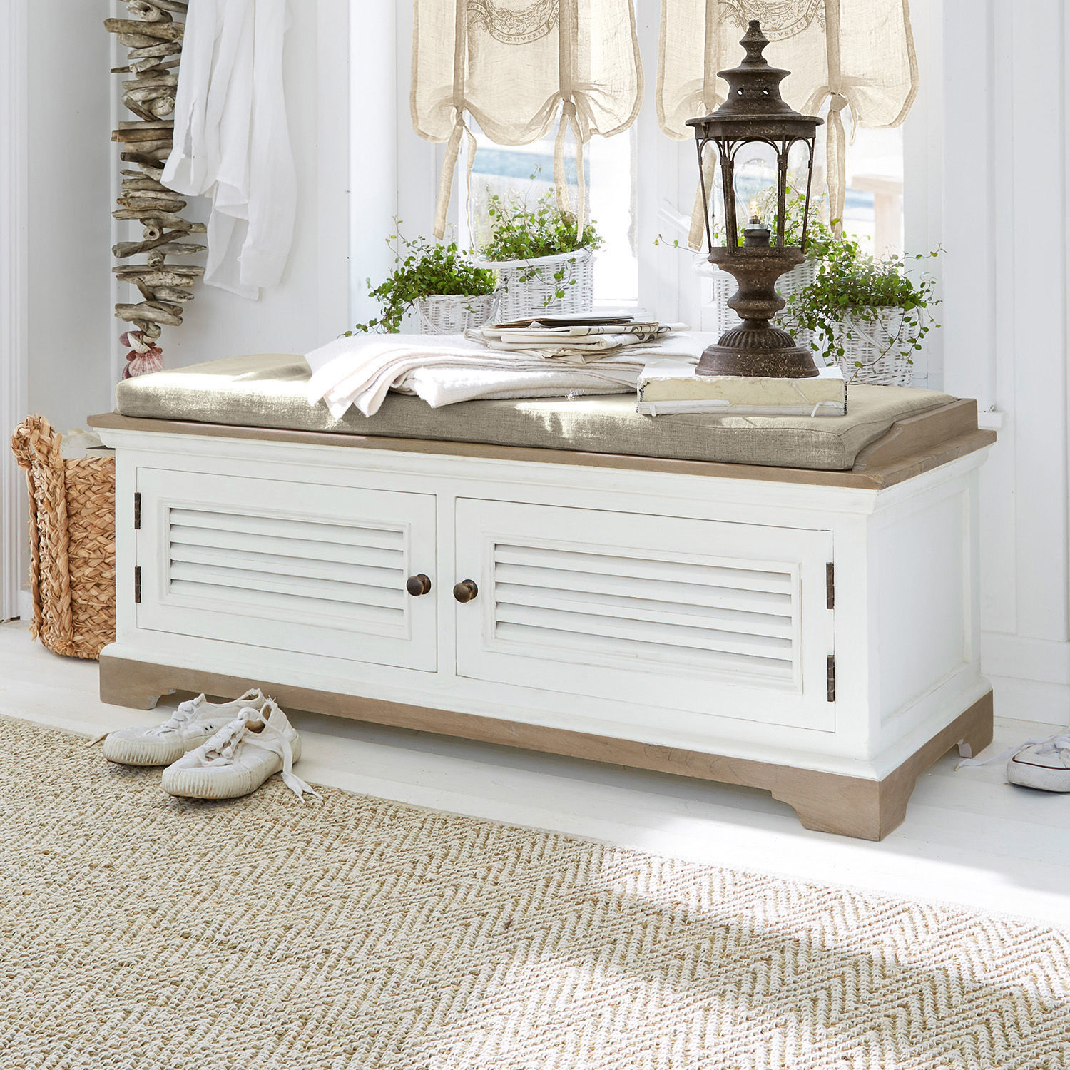 Banc en bois blanc avec coussin beige et rangement, style vintage pour entrée ou salon lumineux