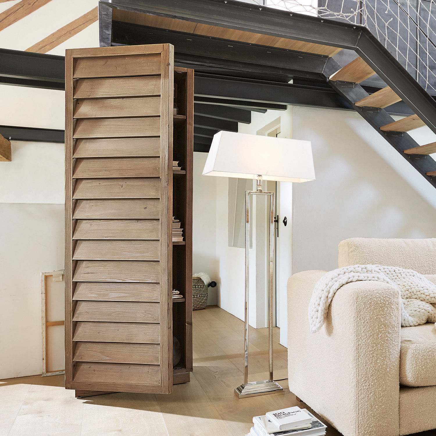 Houten kast met lamellen deuren in natuurlijke kleur in moderne woonkamer met lamp en bank