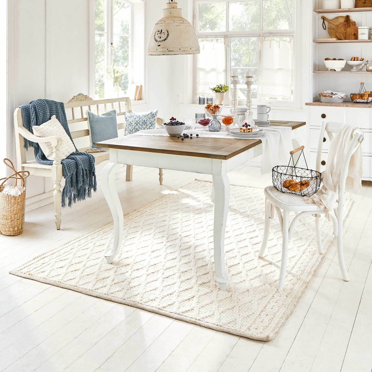 Tapis Poloma Table en bois clair avec plateau naturel et base blanche dans une salle à manger lumineuse décorée